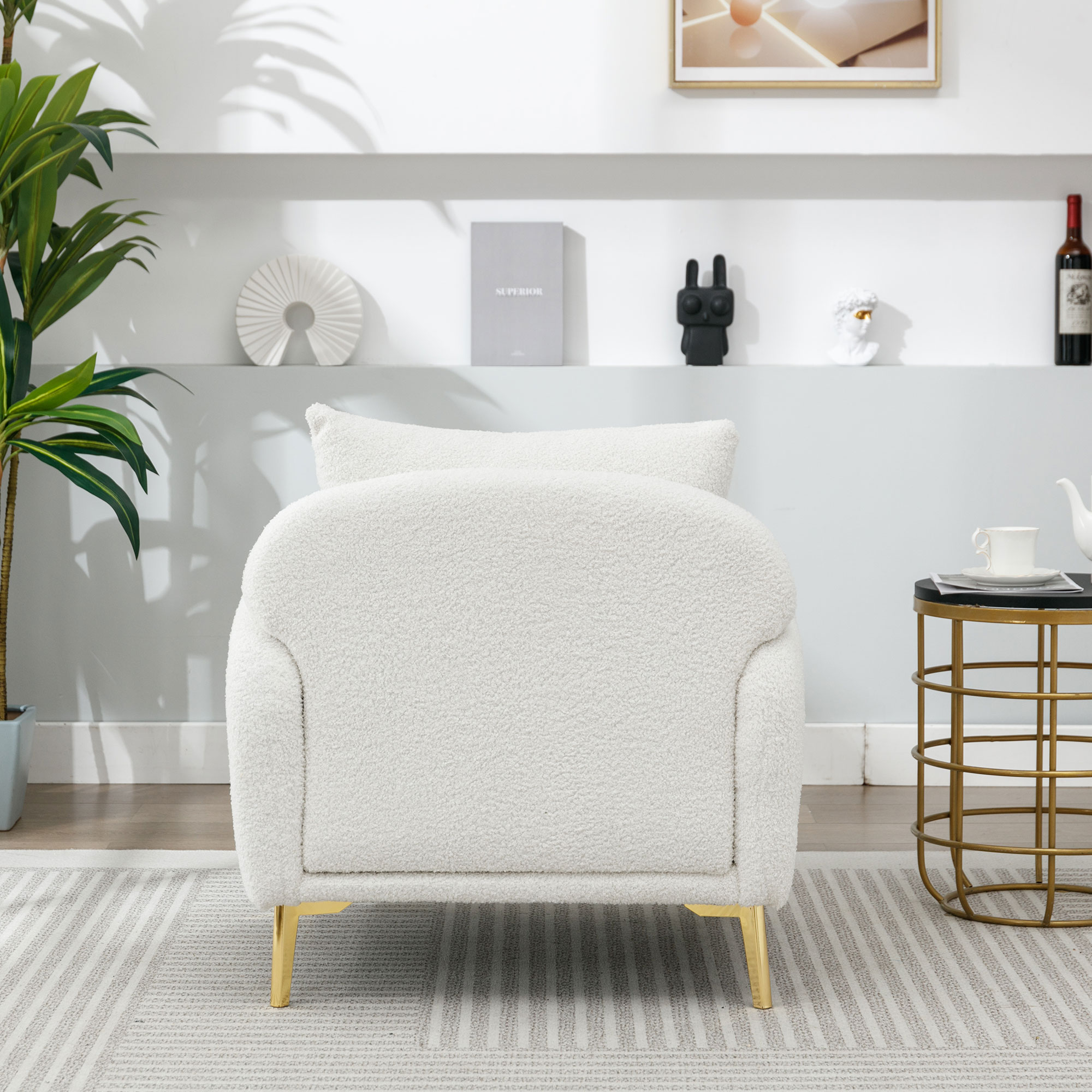 Ein weißer, flauschiger Sessel mit goldenen Beinen, platziert in einem Wohnzimmer.