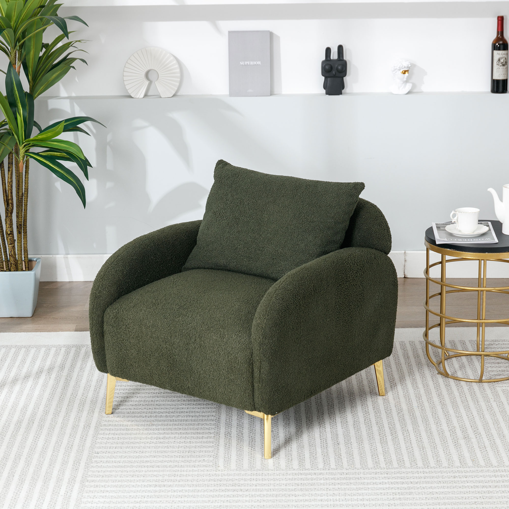 Ein grüner Sessel mit goldenen Beinen, einem Kissen und einem schwarzen Beistelltisch. Der Hintergrund zeigt einen Raum.