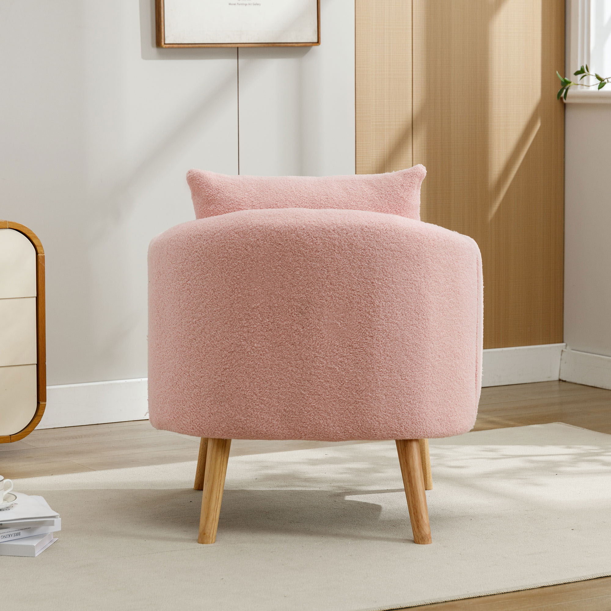 Rosa, runder Stuhl mit Kissen. Der Stuhl hat Holzbeine.