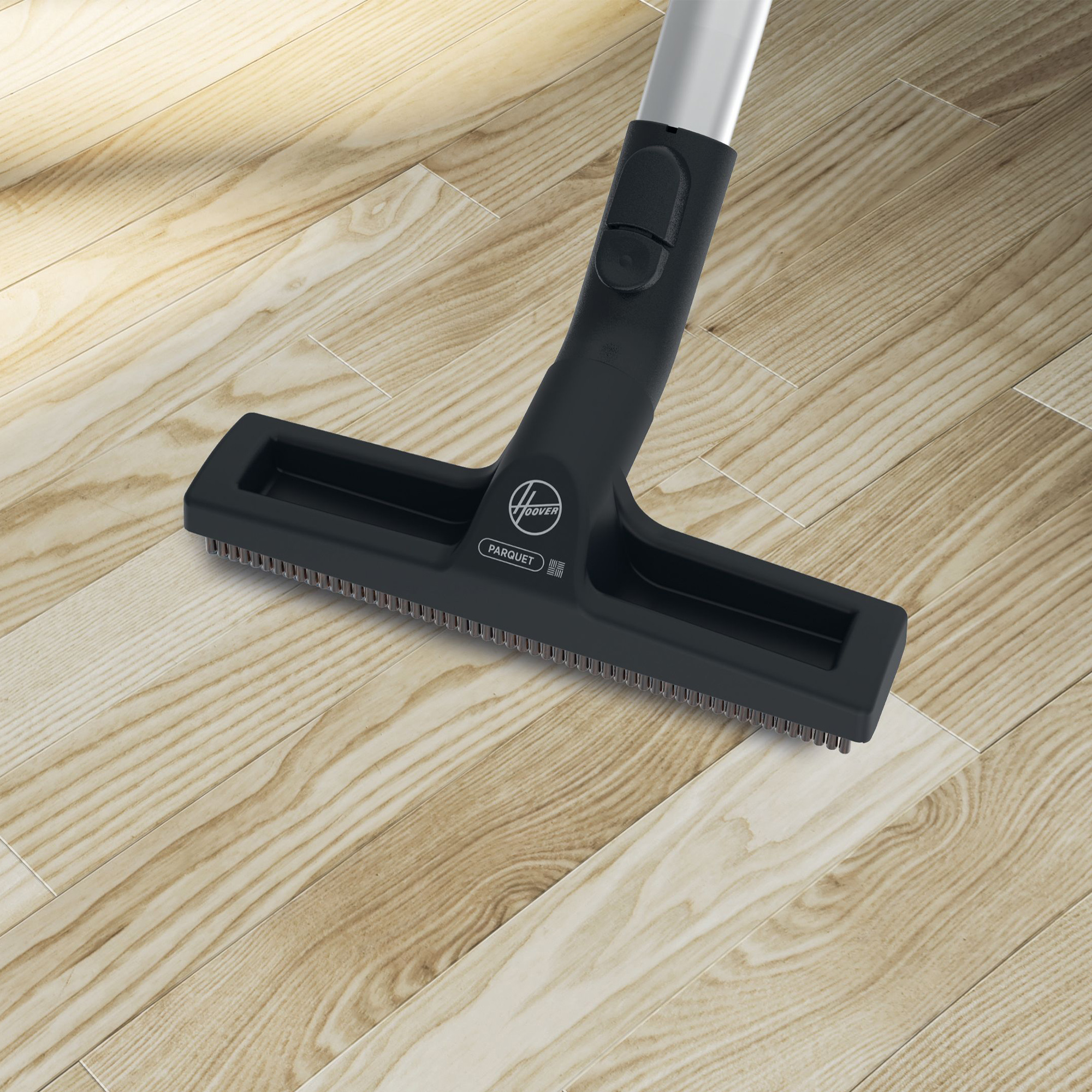 Testa aspirapolvere Hoover parquet su pavimento in legno chiaro. Nero e argento.