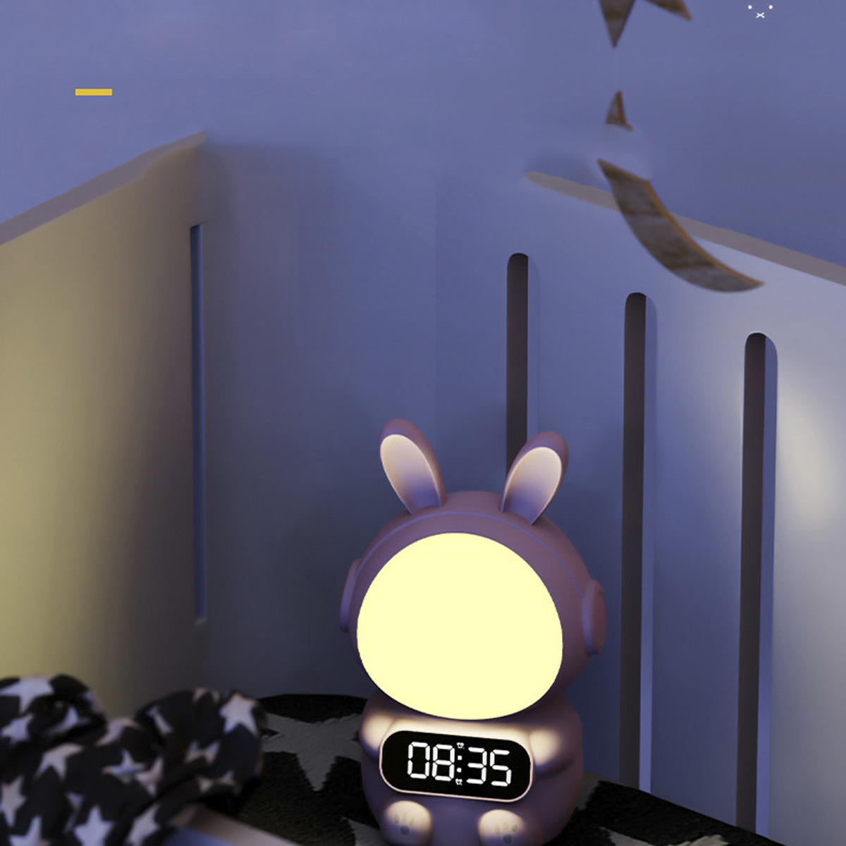 Ein rosa hasenförmiges Nachtlicht mit Digitaluhr, in einem Kinderzimmer.