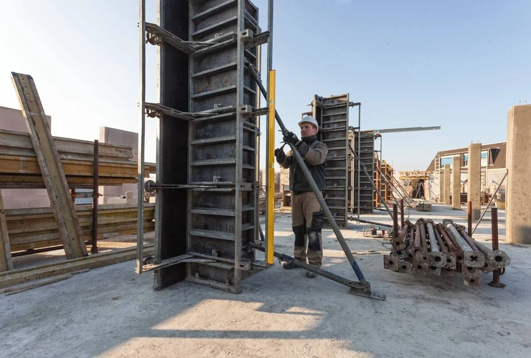 Baustelle mit Arbeiter. Stahlkonstruktionen und Ausrüstung sind sichtbar. Der Tag ist sonnig.