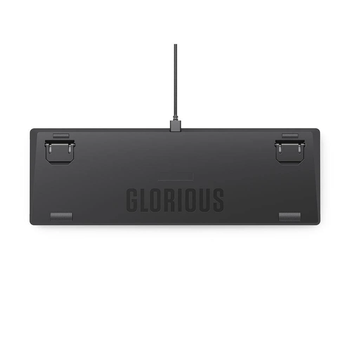 Unterseite einer schwarzen Tastatur mit der Marke 'GLORIOUS'. Das Bild befindet sich auf weißem Hintergrund.