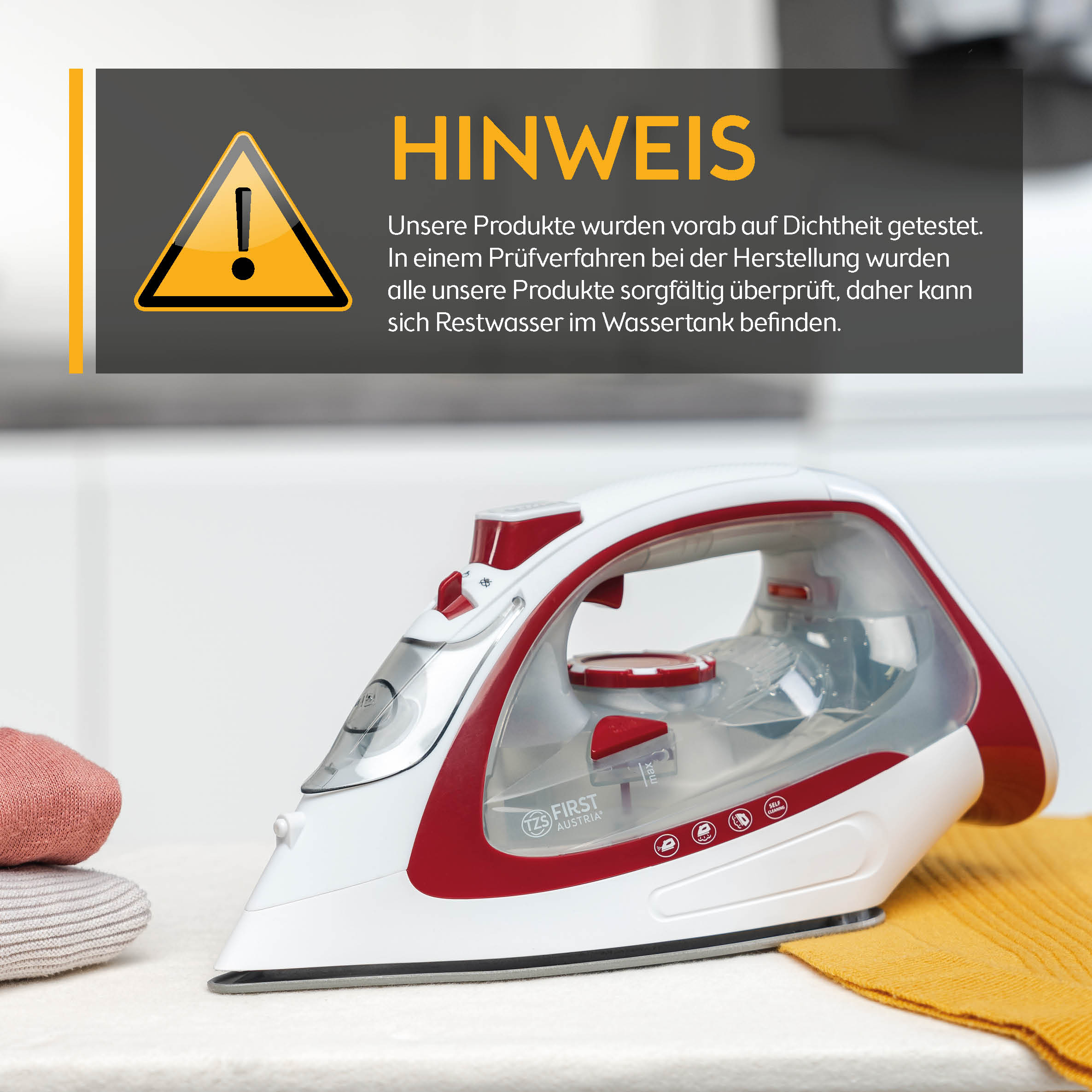 Weißes und rotes Bügeleisen auf einem Tisch mit einem Warnschild im Hintergrund.