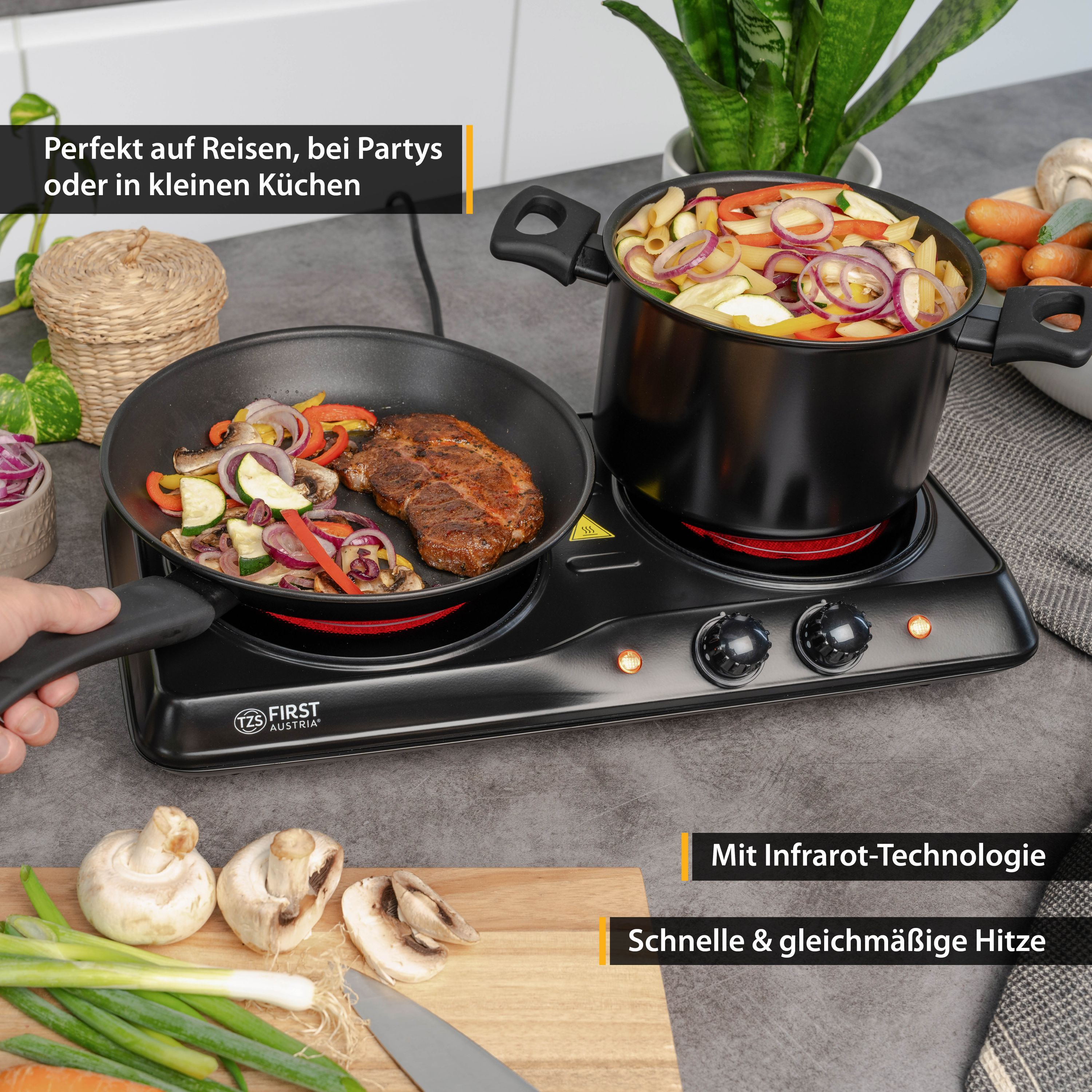 Schwarze Elektro-Kochplatte mit Essen. Gemüse und Steak werden gebraten. Töpfe und Pfannen sind drauf.