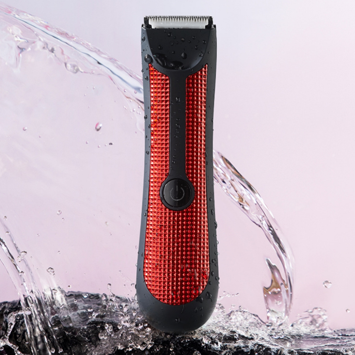 Ein schwarzer und roter Bodygroomer mit Wasser, das vor rosa Hintergrund spritzt.