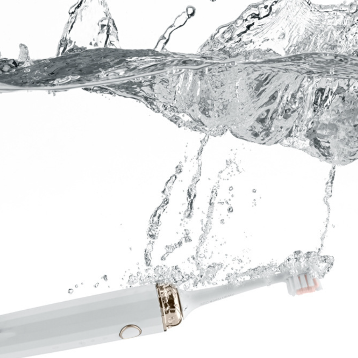 Elektrische Zahnbürste unter Wasser, Wasser spritzt, weißer Griff und Bürstenkopf sichtbar.