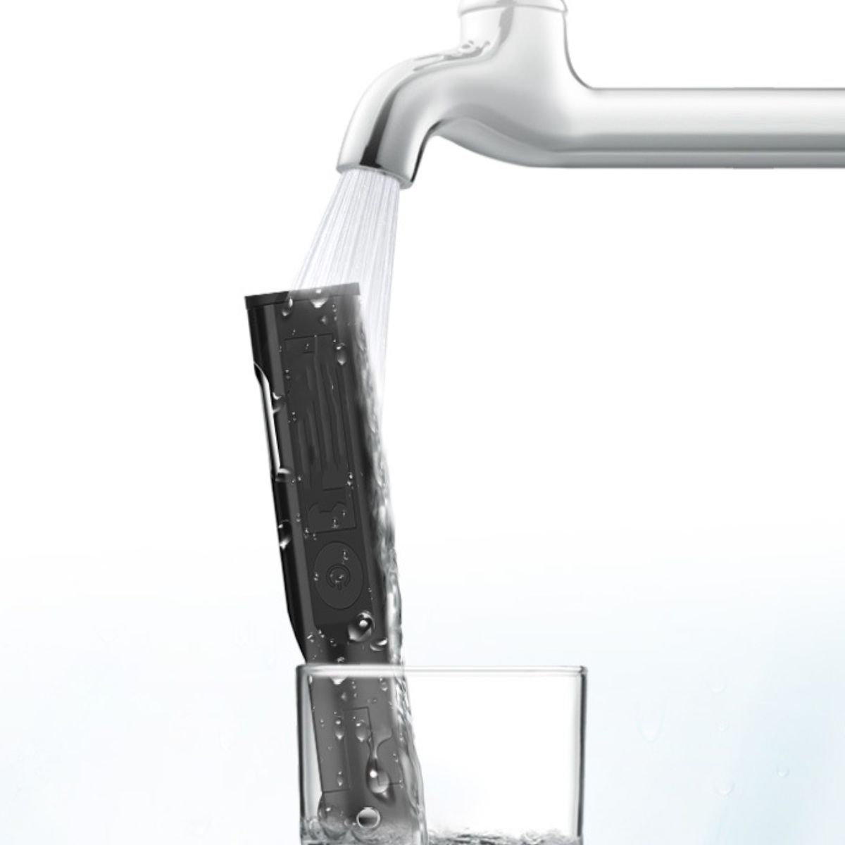 Ein schwarzes Gerät wird unter einem Wasserhahn gespült, Wasser fließt in ein Glas.