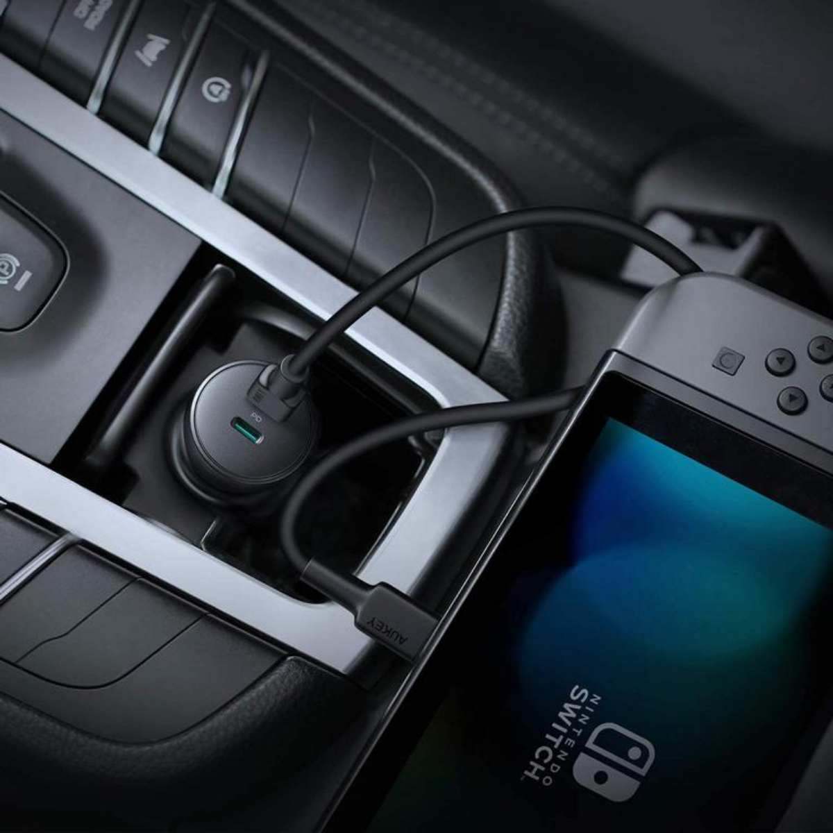 Ein Autoladegerät, das in ein Auto eingesteckt ist und eine Nintendo Switch auflädt.