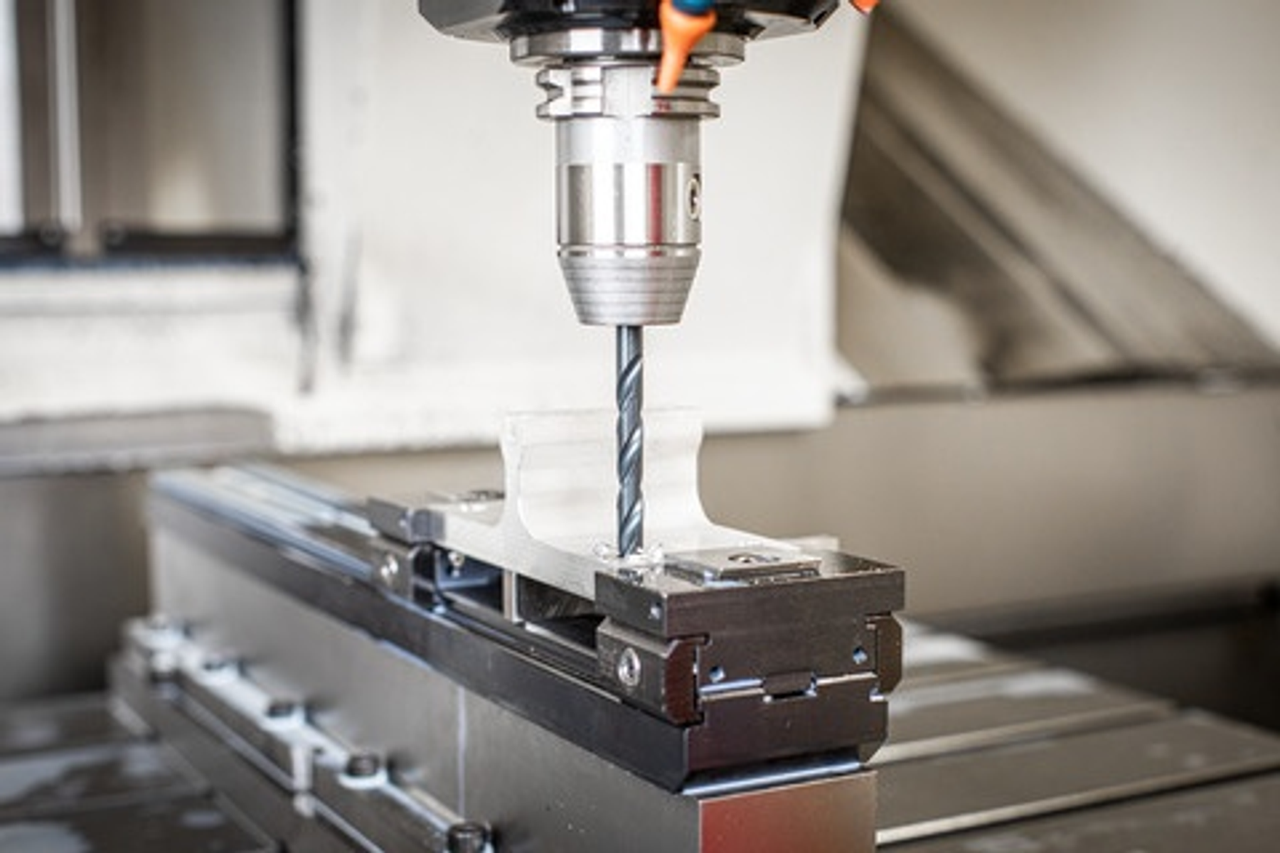 CNC-Maschine mit Bohrer, der in Metall bohrt, industrielle Umgebung.