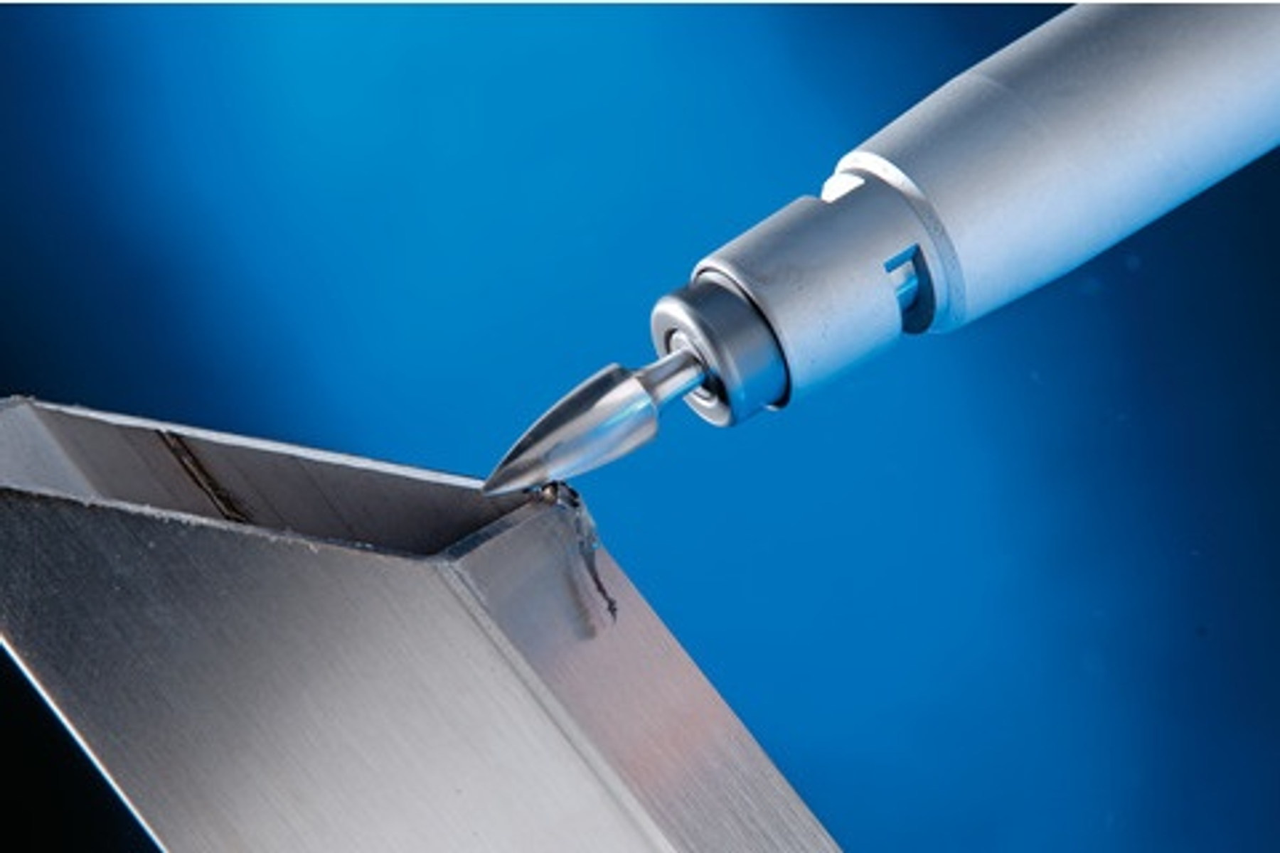 Ein Metallwerkzeug wird verwendet, um eine Metallecke zu formen, mit blauem Hintergrund.