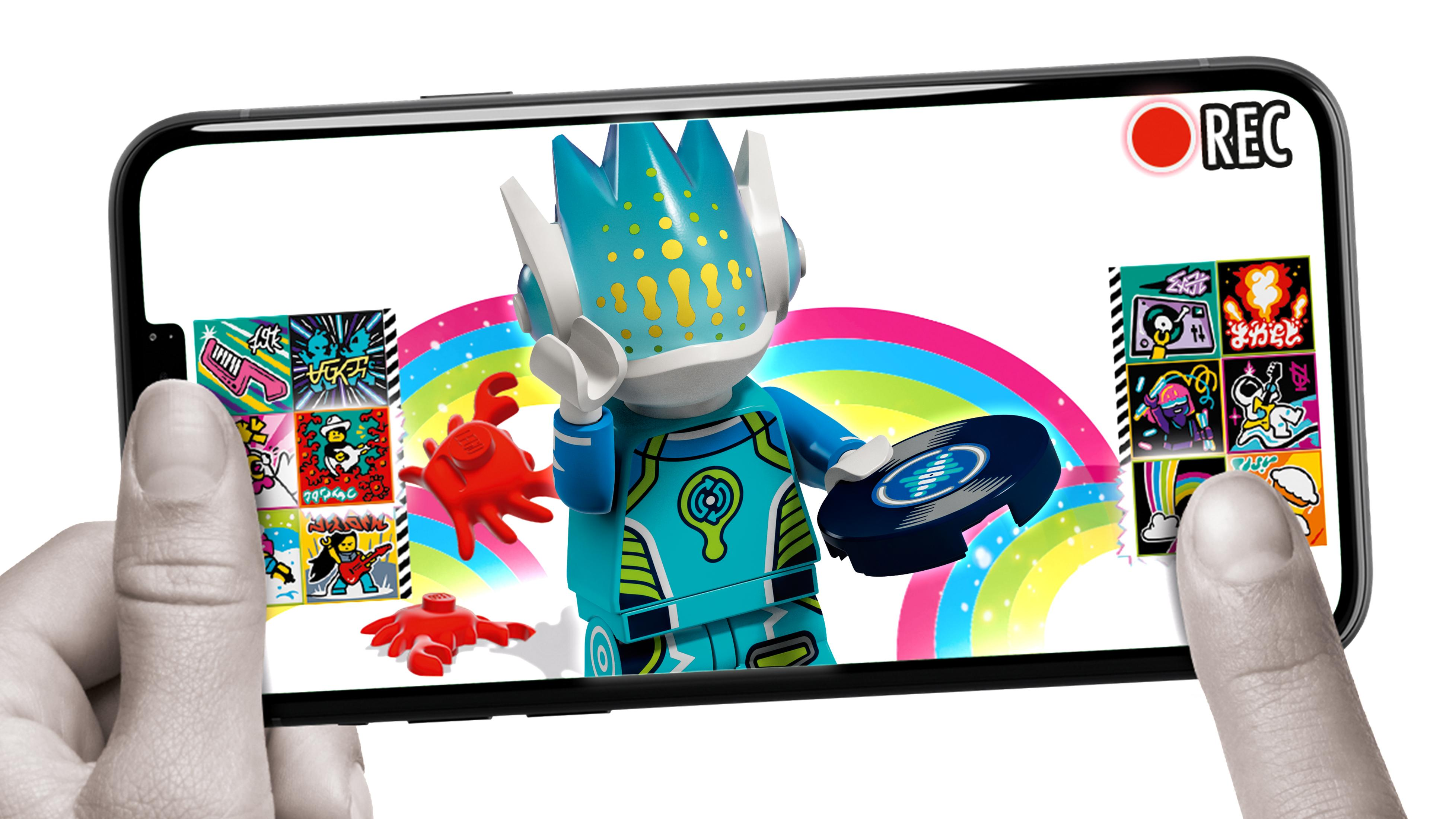 Hände einer Person, die ein Telefon halten. Auf dem Bildschirm ist eine Lego-Figur mit Regenbogen zu sehen.