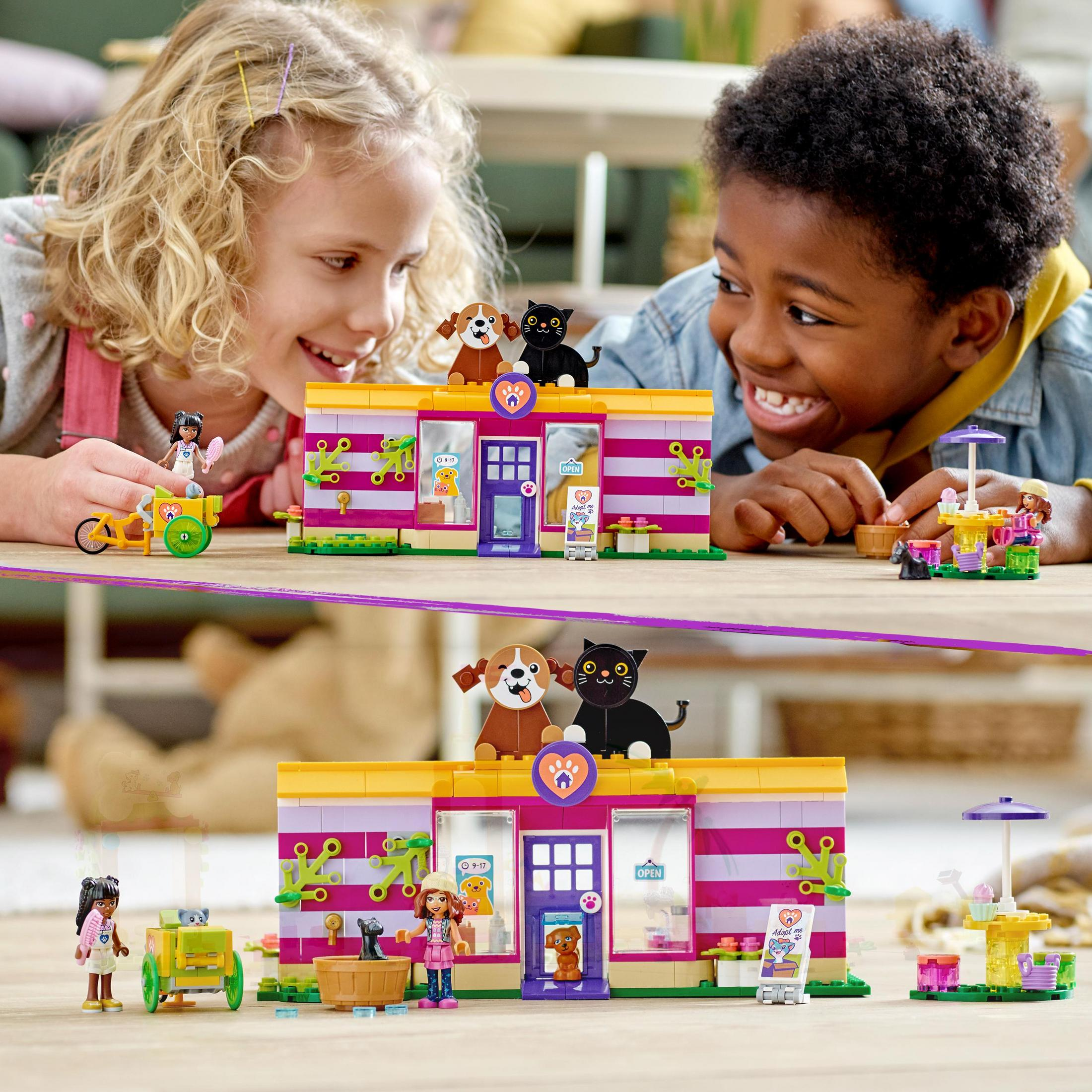 Zwei Kinder spielen mit einem Lego-Tierladen-Set, mit Hunden und Katzen auf dem Dach und vor dem Laden.