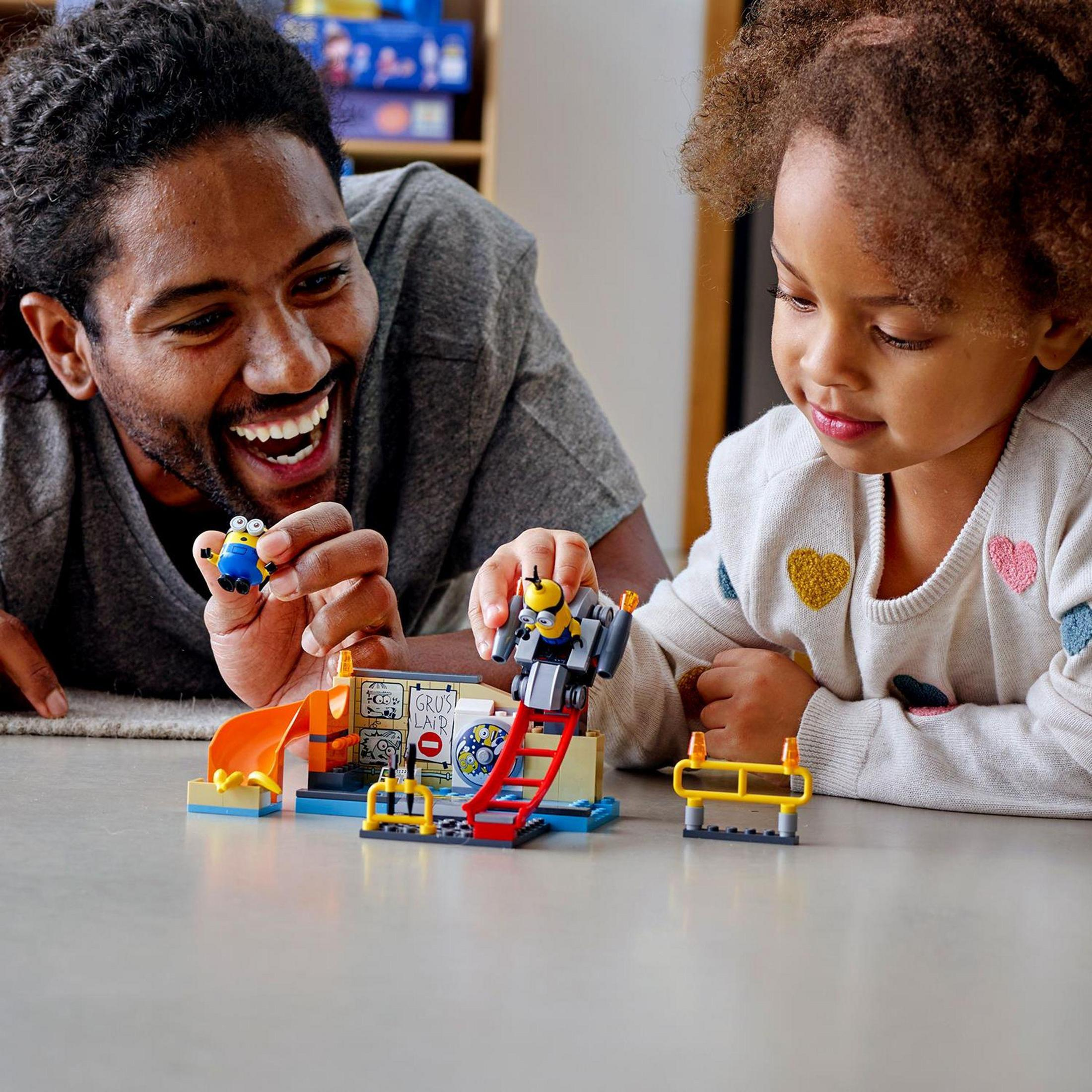 Vater und Kind spielen mit Spielzeug-Bausatz mit Minion-Figuren. Drinnen.
