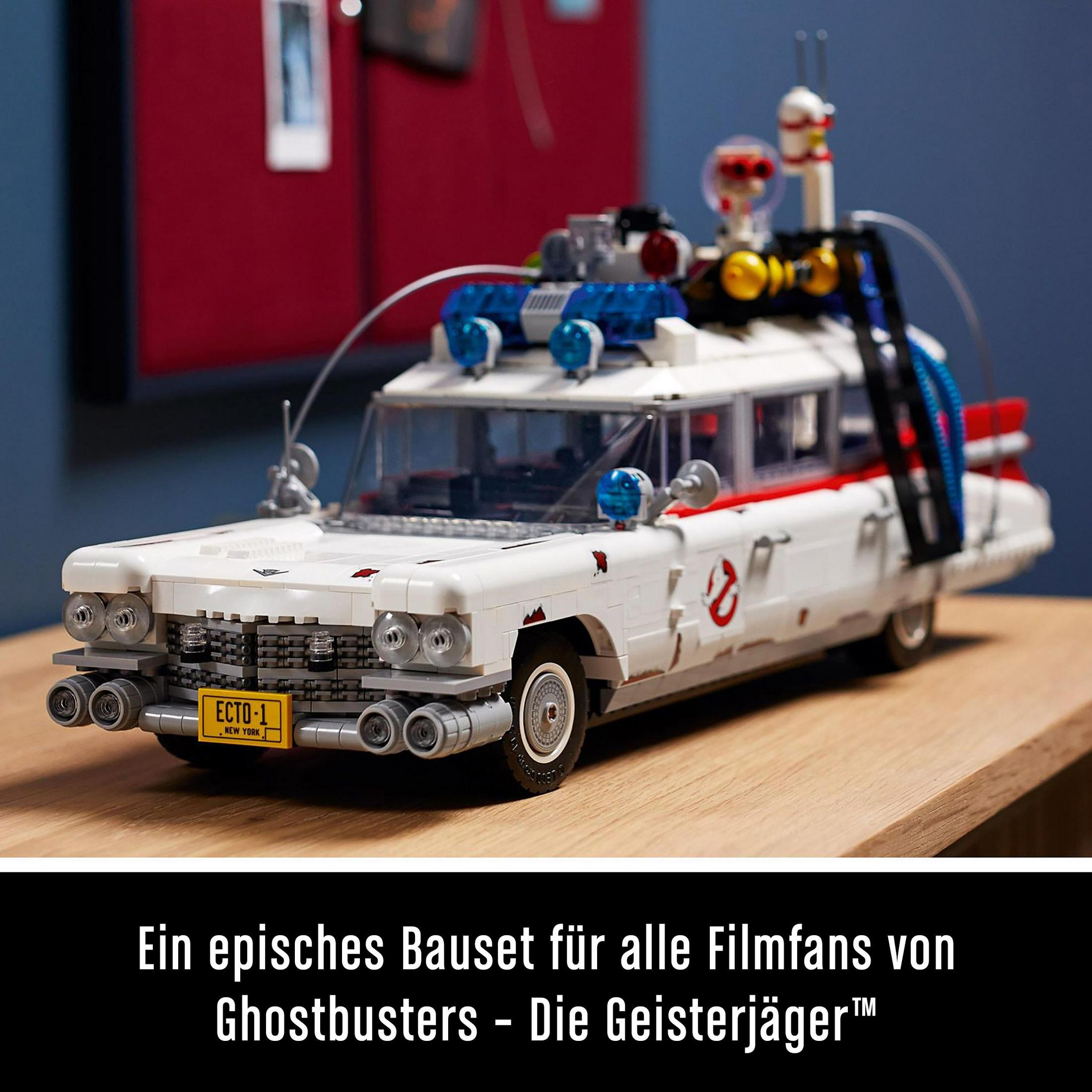 Biały zestaw Lego Ecto-1 Ghostbusters na drewnianej powierzchni. Tekst: 'Epicki zestaw'.