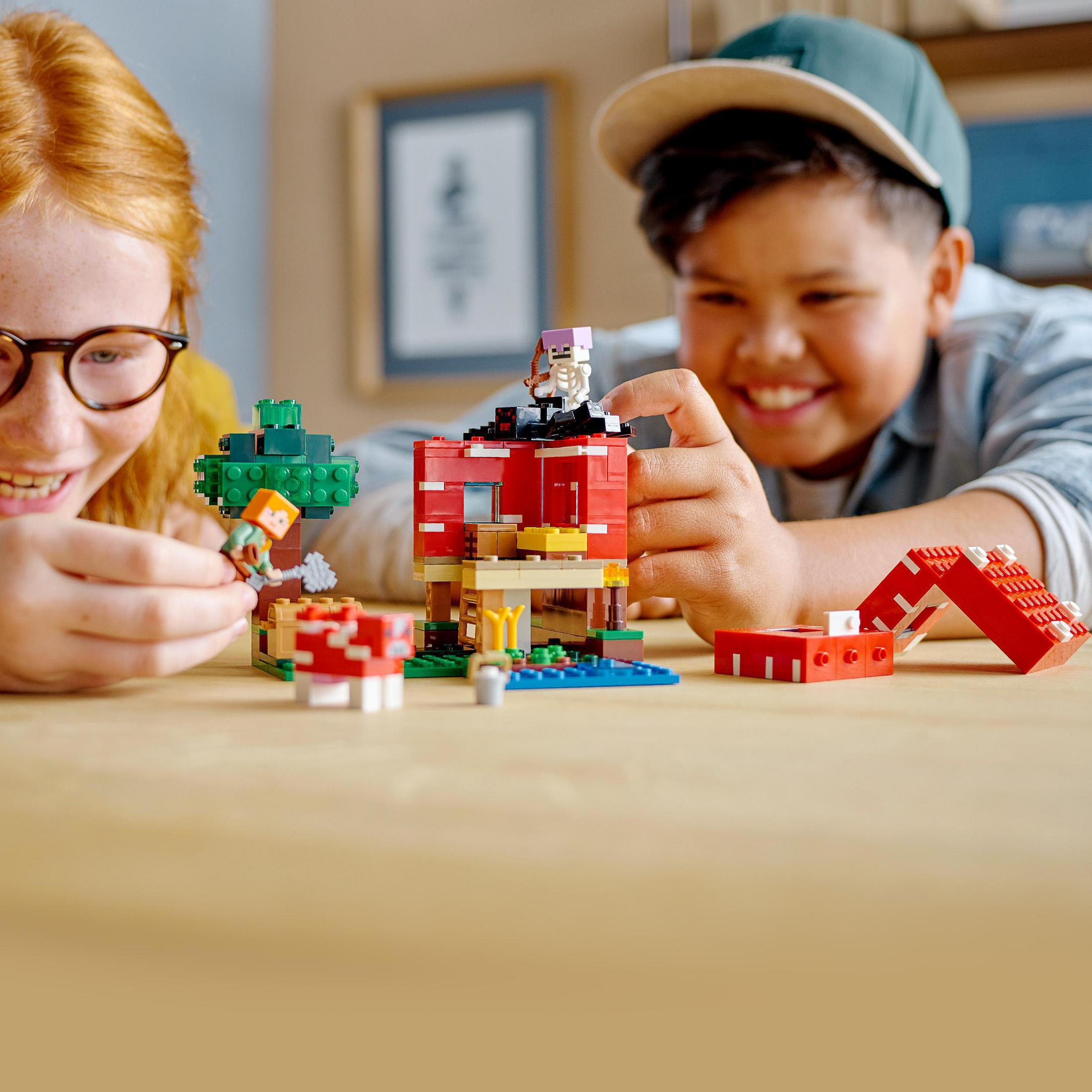 İki çocuk, bir Minecraft sahnesi inşa etmek için Lego tuğlalarıyla oynuyor.