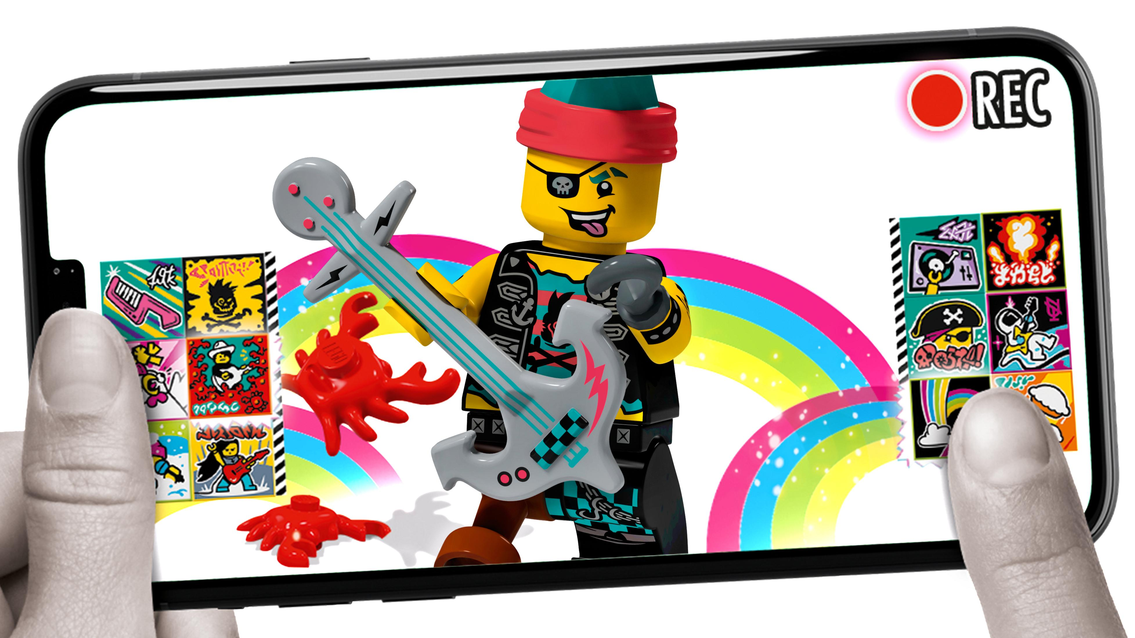Lego-Minifigur auf einem Handy-Bildschirm hält eine Gitarre. Bunter Hintergrund.
