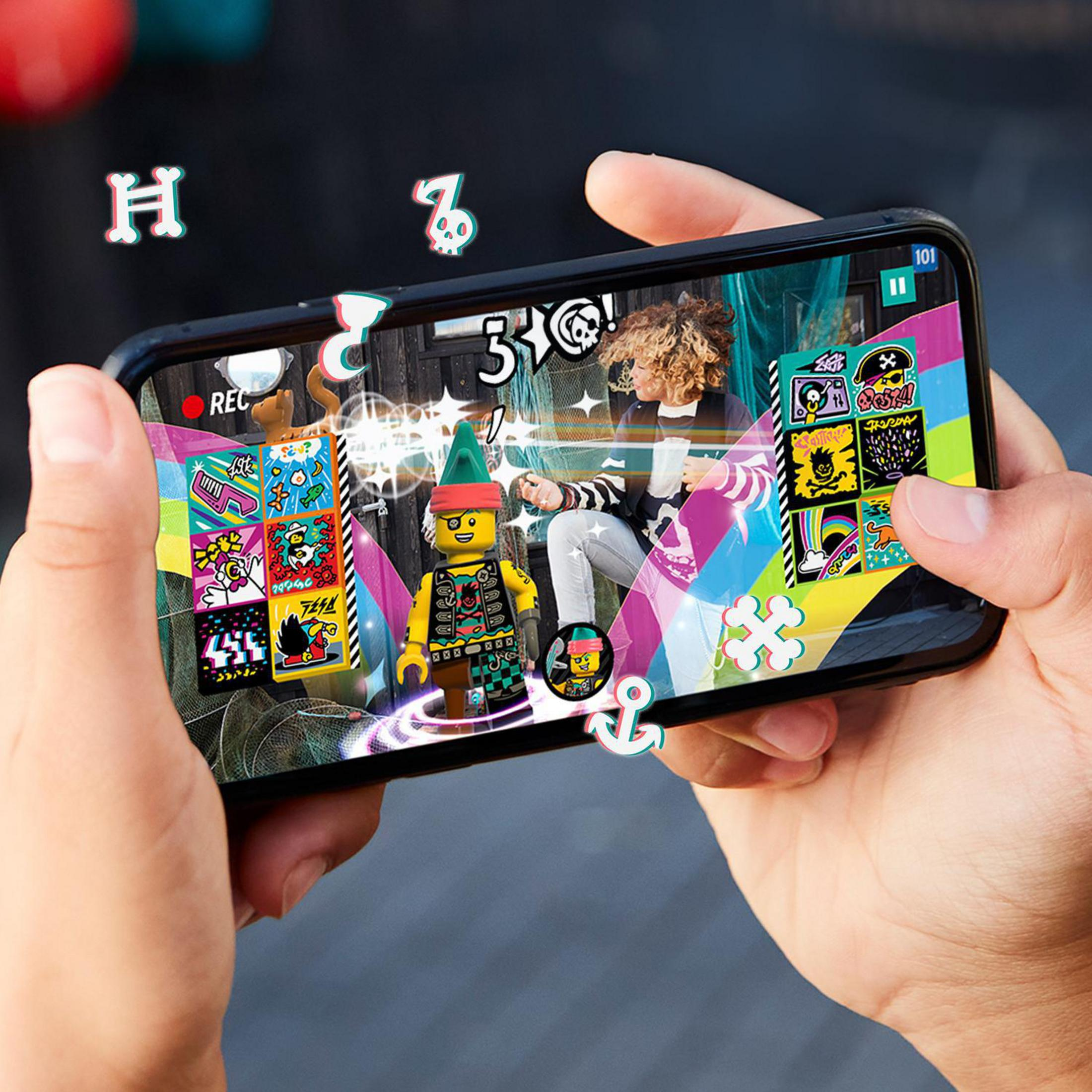 Hände halten ein Telefon, das eine LEGO-Figur in Augmented Reality mit Spielsymbolen anzeigt.