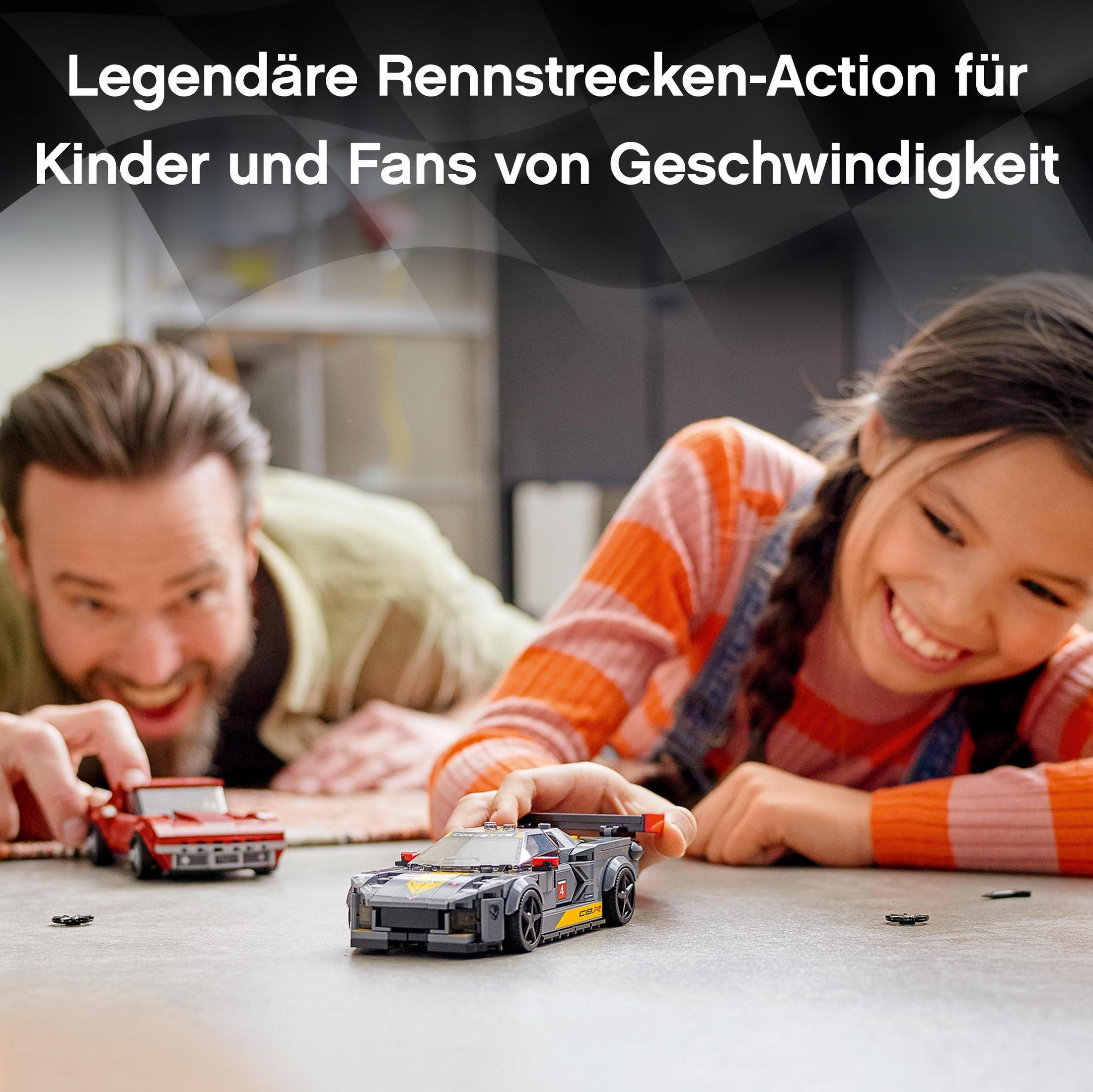 Ein Vater und ein Kind spielen mit Spielzeugautos auf einem Tisch. Die Lego-Autos sind grau und rot.