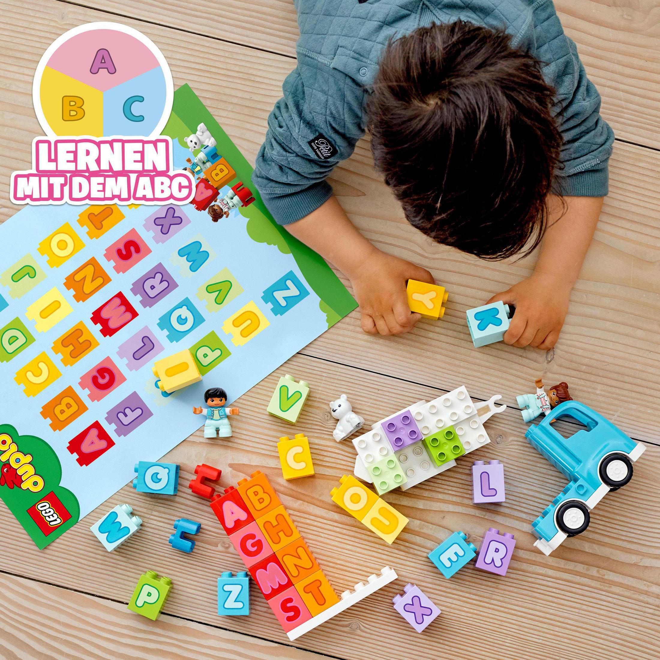 Ein Kind spielt mit Legosteinen und lernt das Alphabet.