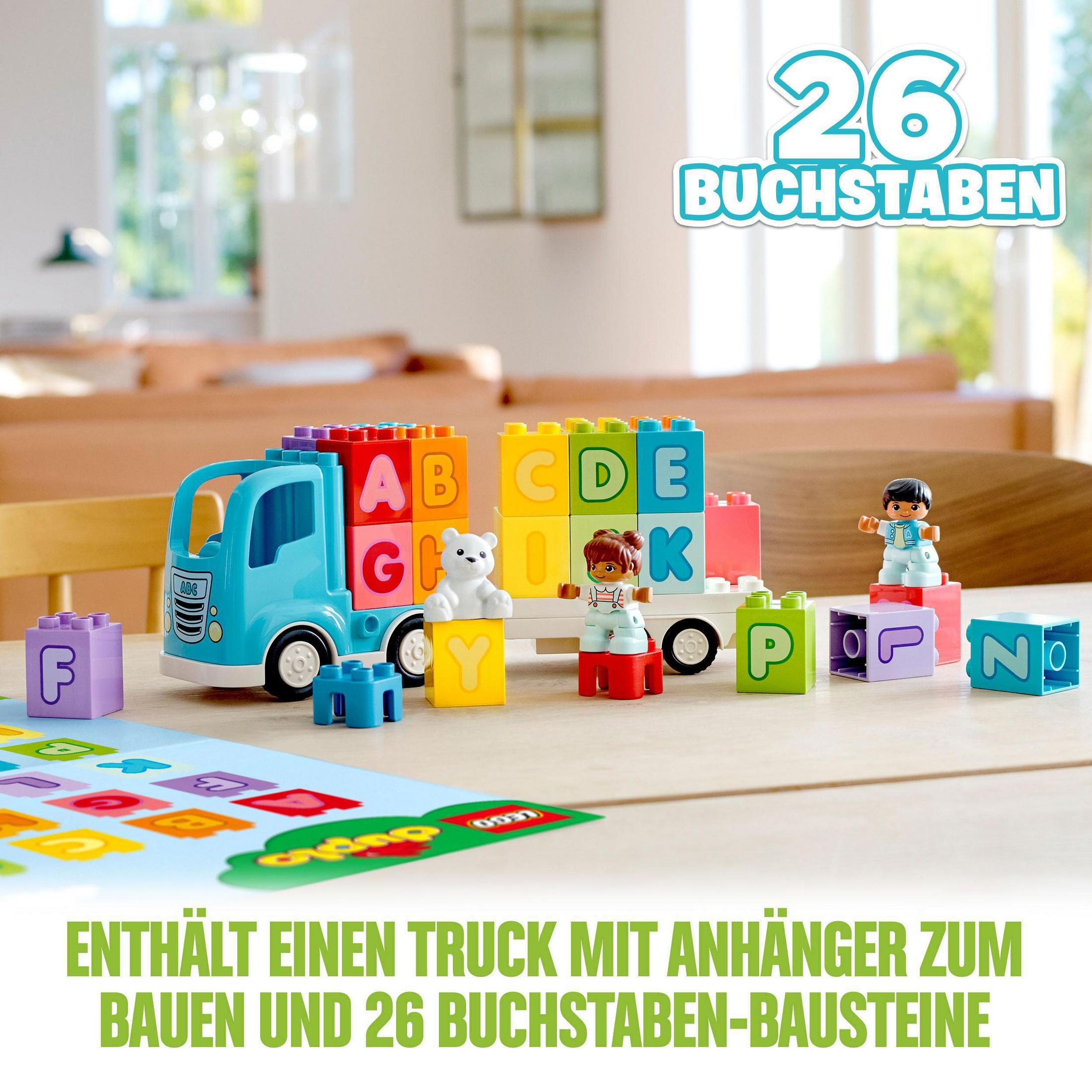 Ein blauer Spielzeug-LKW mit farbigen Blöcken mit Buchstaben und Figuren und drei Spielfiguren.