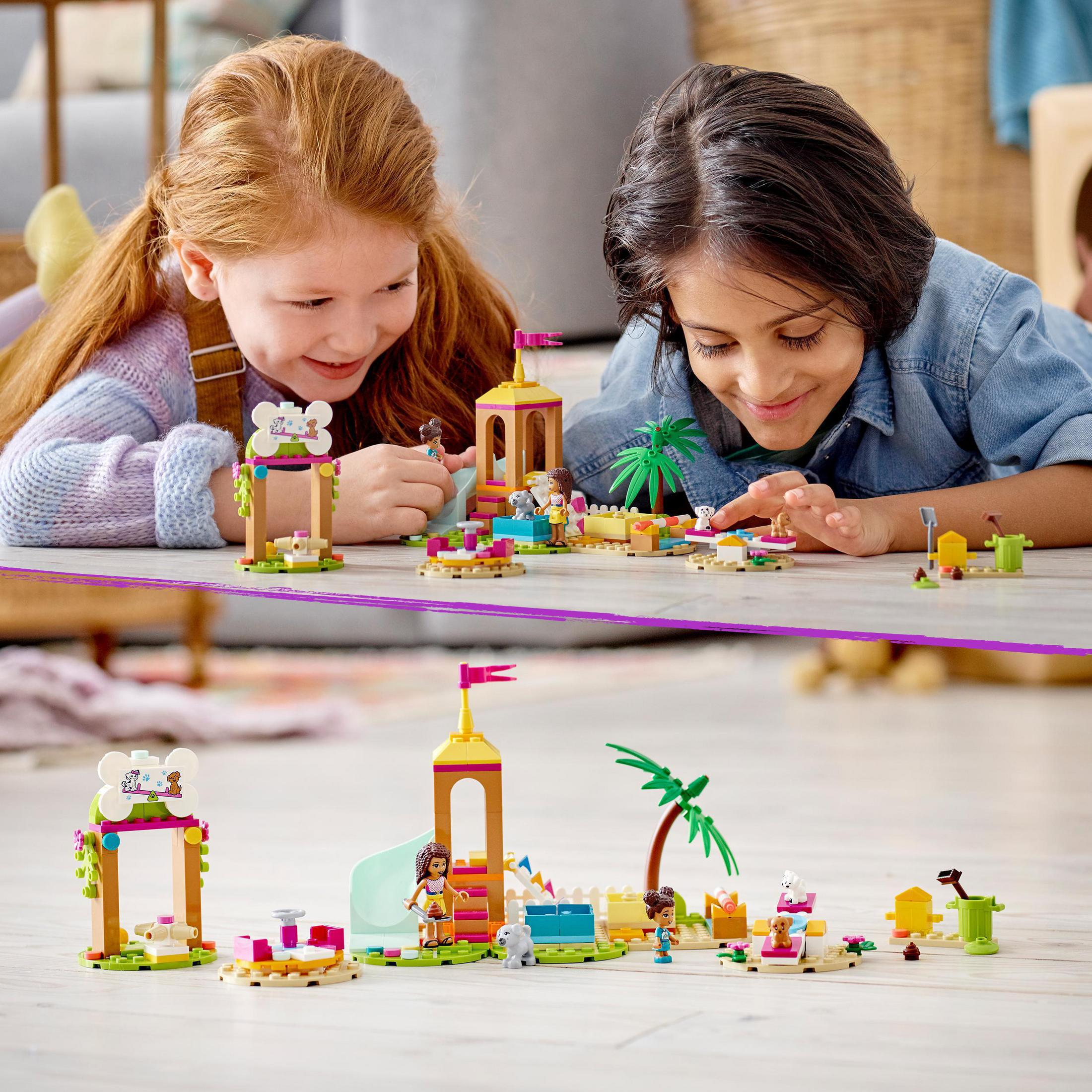 Zwei Kinder spielen mit einem LEGO-Set. Das Set hat eine Rutsche, einen Turm und kleine Figuren auf einem Holzboden.