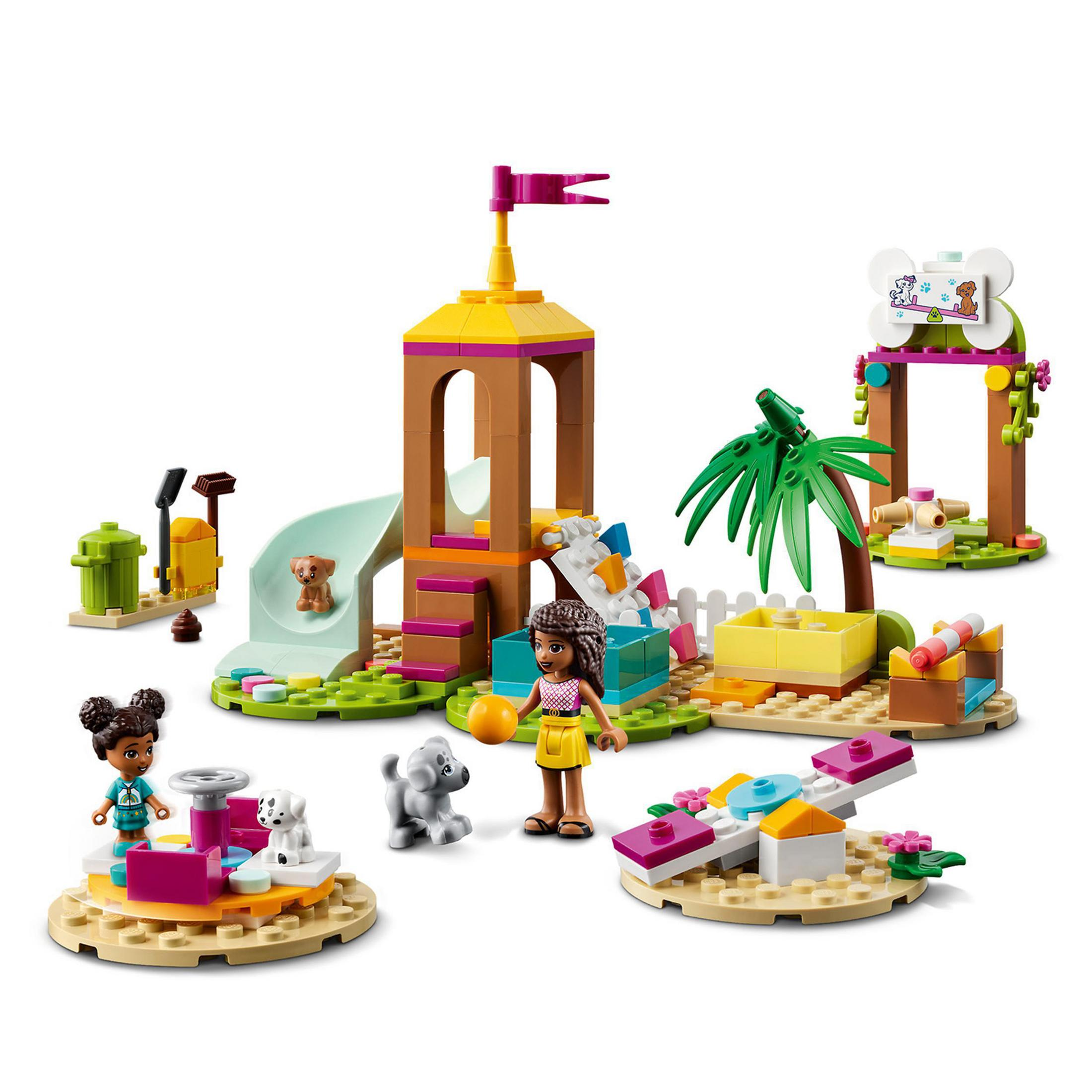 Lego-Set mit Spielplatz. Enthält Rutsche, Wippe und Hundefiguren. Zwei Mädchen und ein Junge sind da.