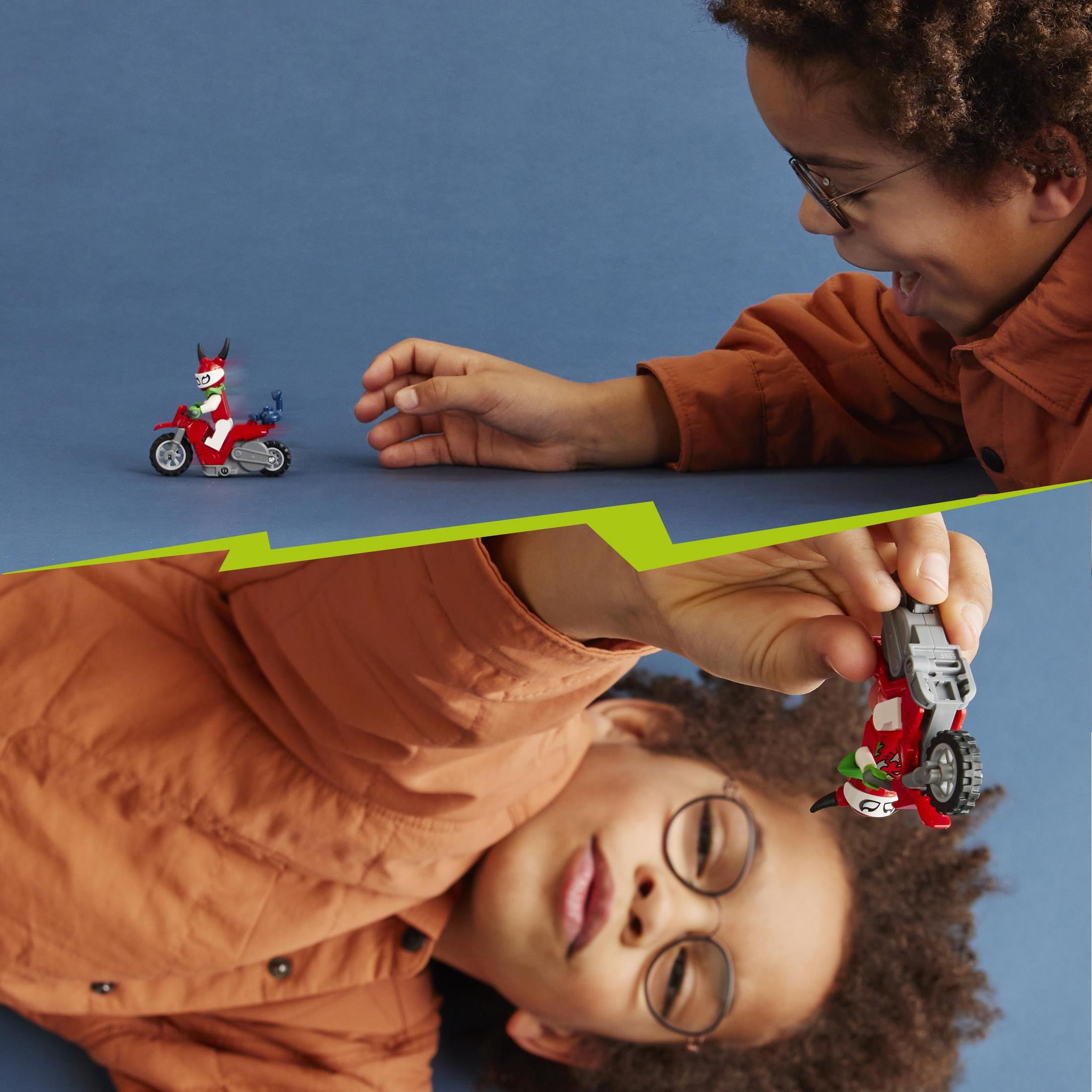 Un niño juega con un set de motocicleta LEGO. El set y el niño son visibles en el encuadre.