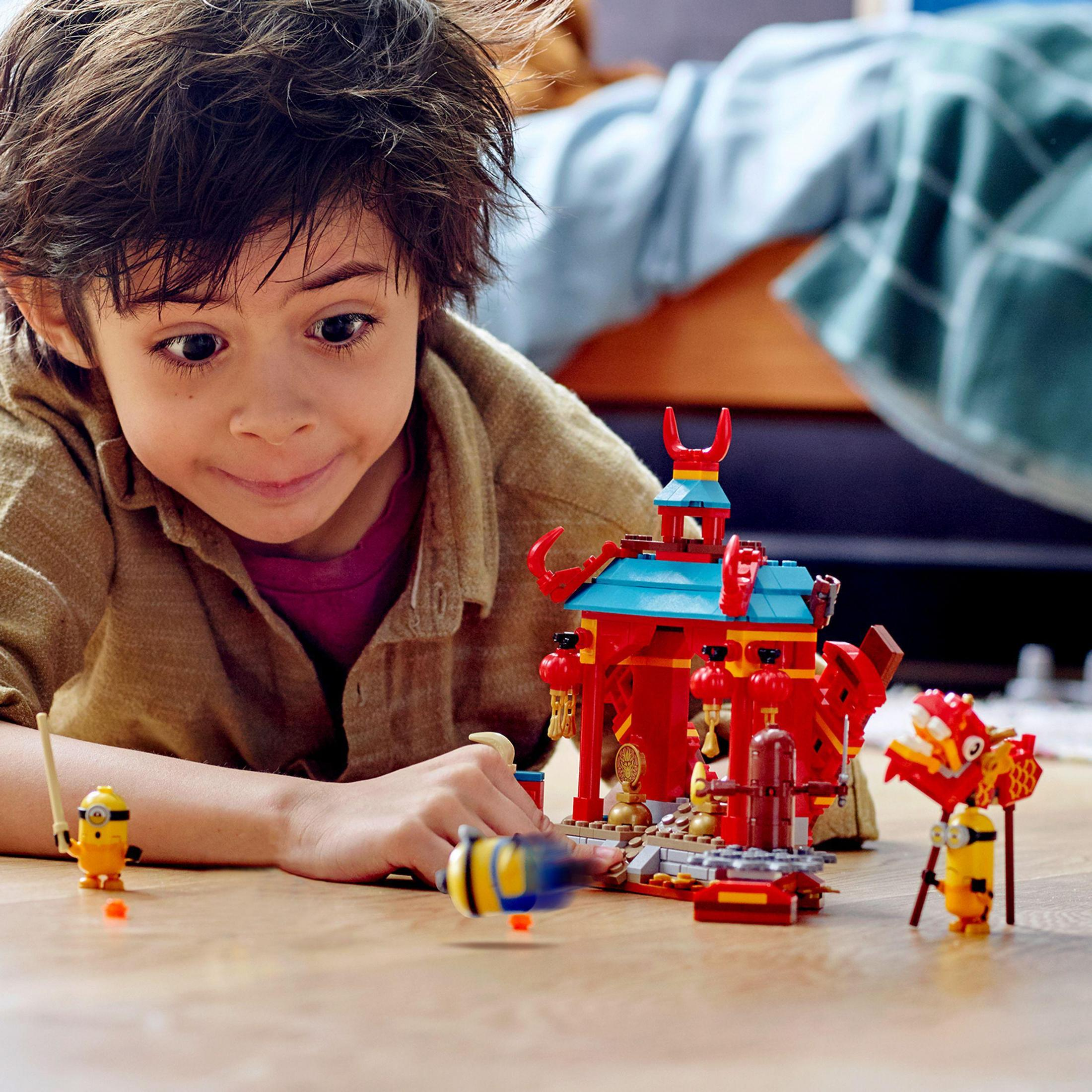 Ein Junge spielt mit einem Lego-Set mit einem chinesischen Tempel und Minifiguren.