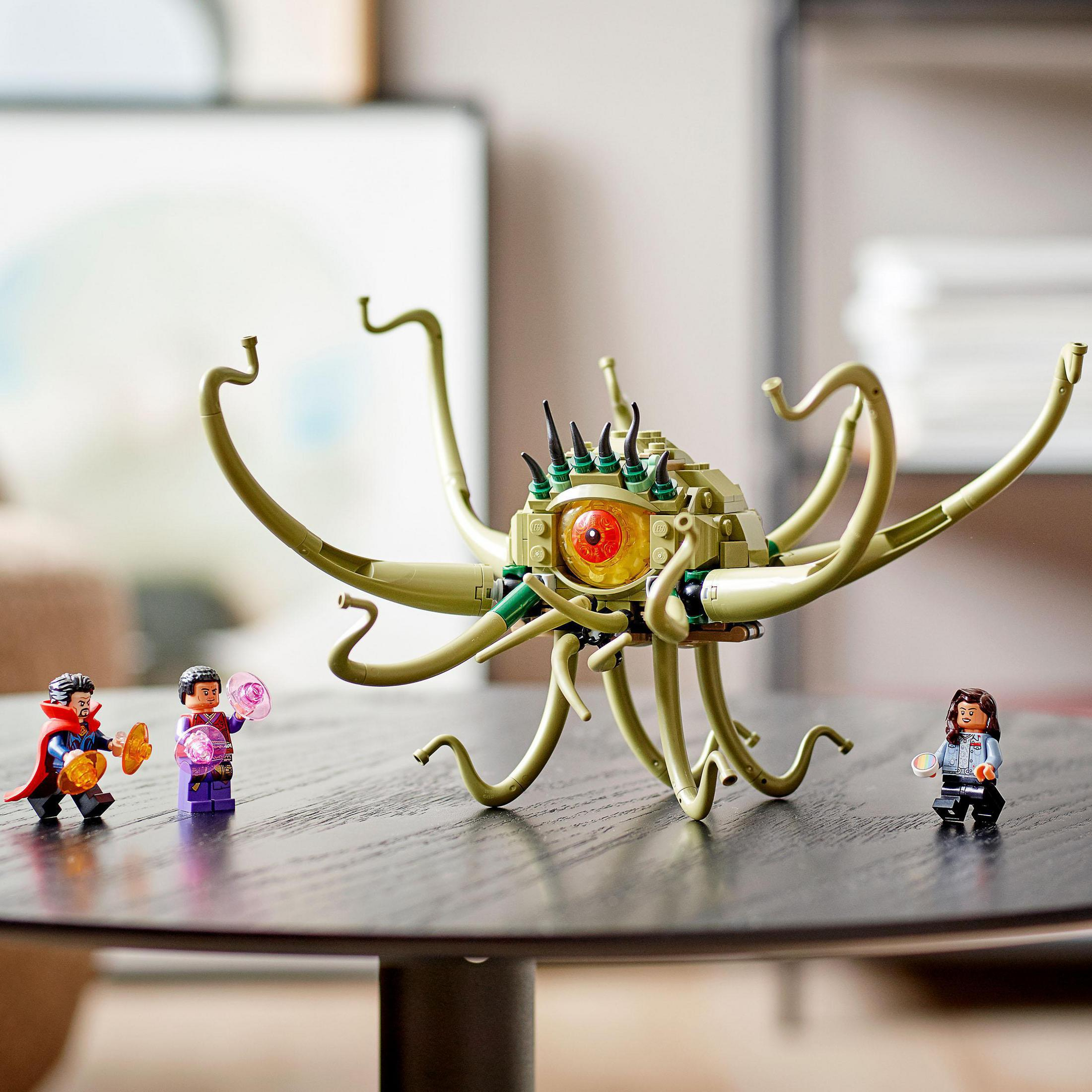 Lego-Set mit Doctor Strange, Wong und einer Kreatur. Dunkler Tisch, verschwommener Hintergrund.