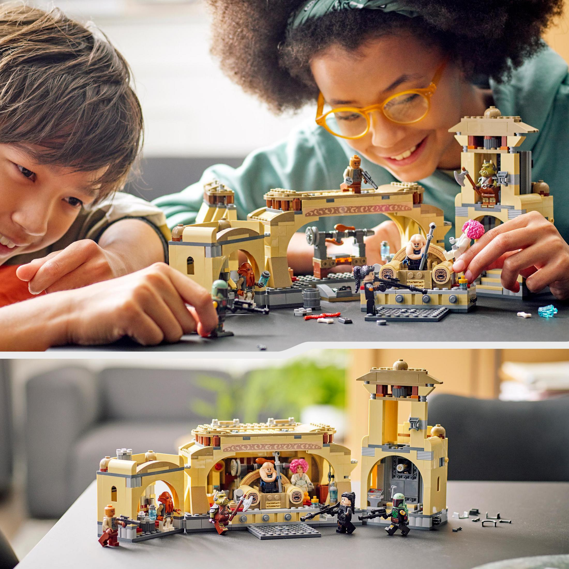 Niños jugando con set Lego Star Wars. El set muestra escena desértica con edificios y personajes.