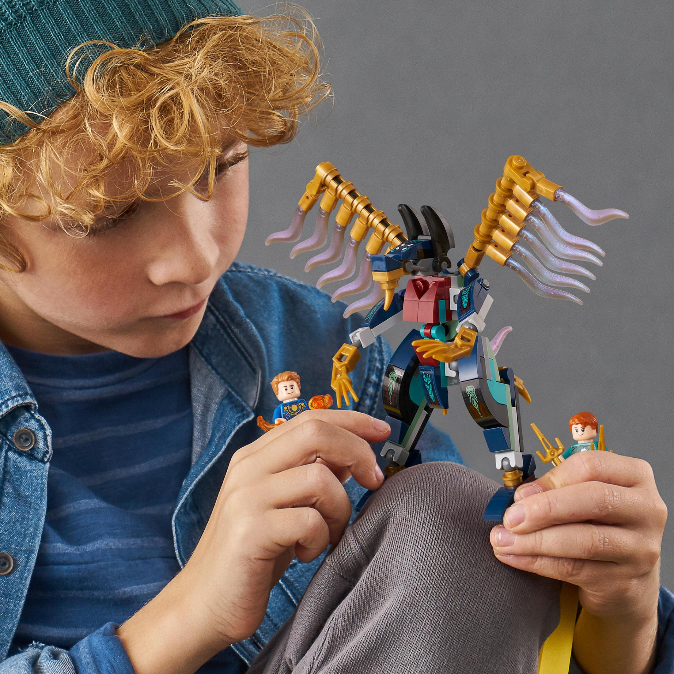 Ein Junge spielt mit Lego-Spielzeug. Lego-Drache und Minifiguren im Fokus.