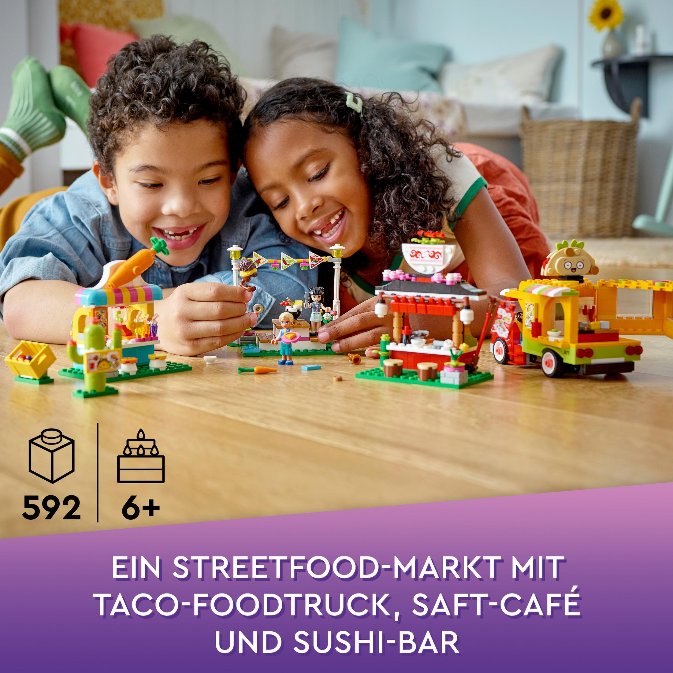 Zwei Kinder spielen mit einem Lego-Streetfood-Marktset mit Foodtrucks.