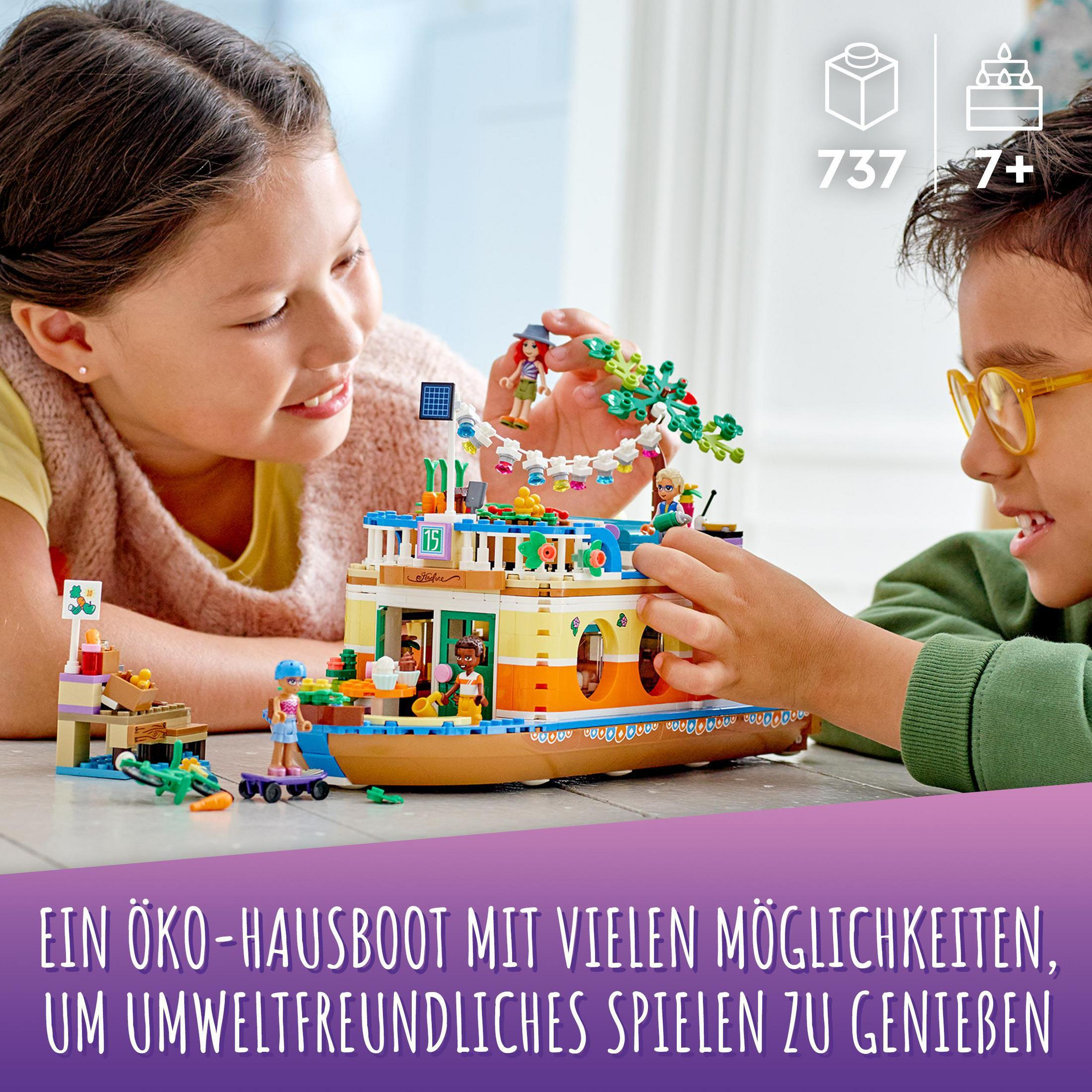 Zwei Kinder spielen mit einem Lego-Hausboot. Das Boot ist gelb und blau.