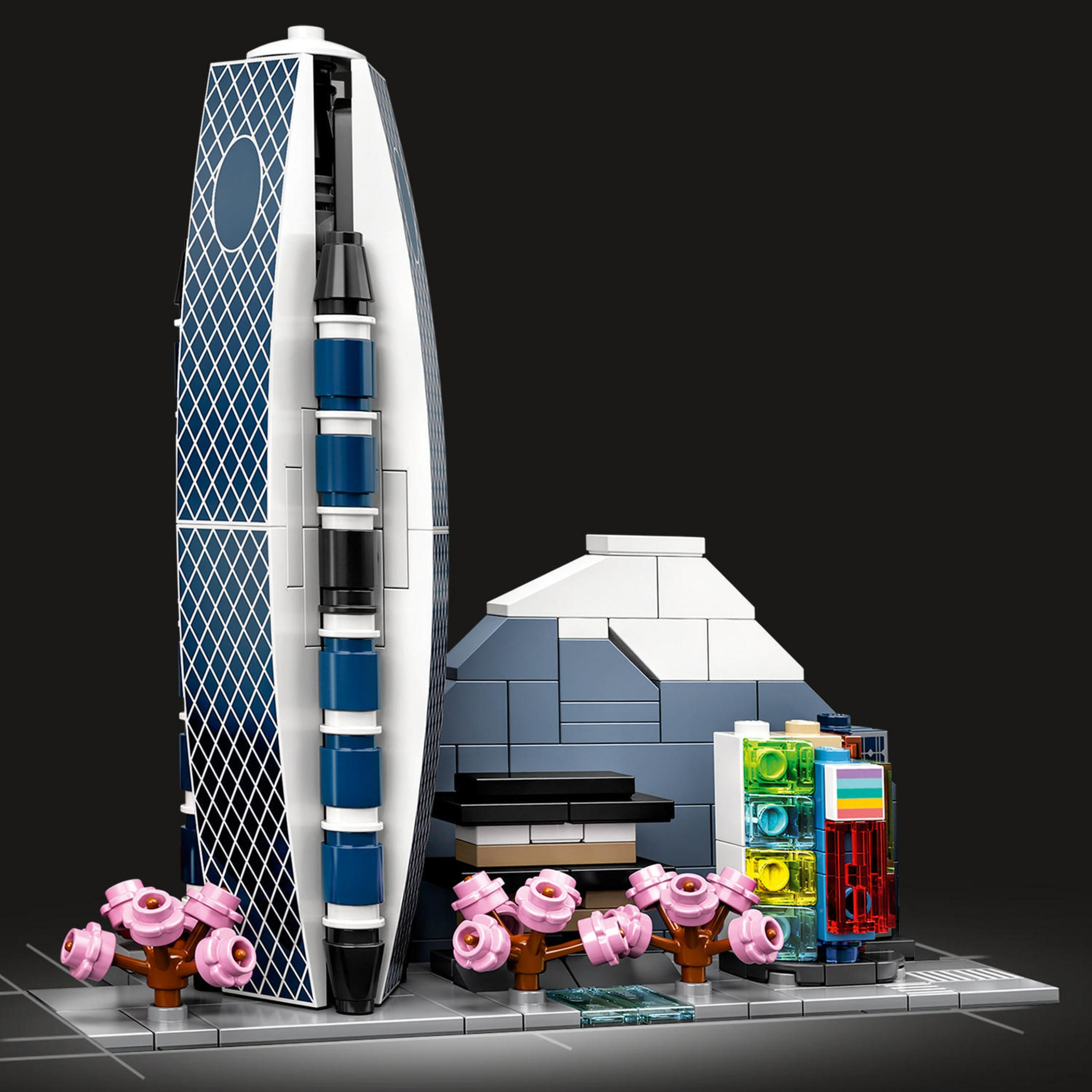 Ein Lego-Modell eines modernen Gebäudes mit einer einzigartigen Struktur, mit einigen rosa Bäumen.