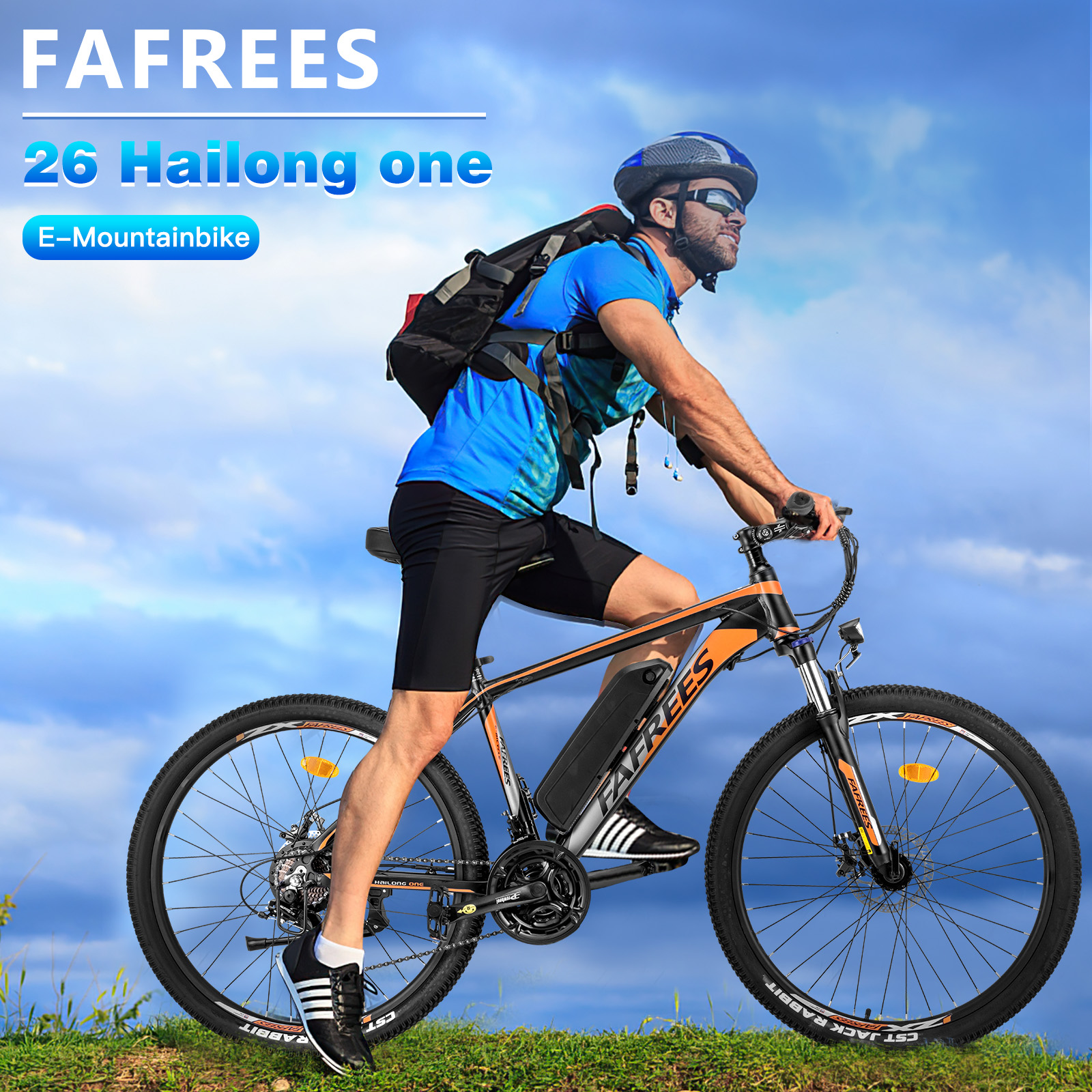 Mann fährt ein E-Mountainbike auf einem grasbewachsenen Hügel unter blauem Himmel mit Wolken.