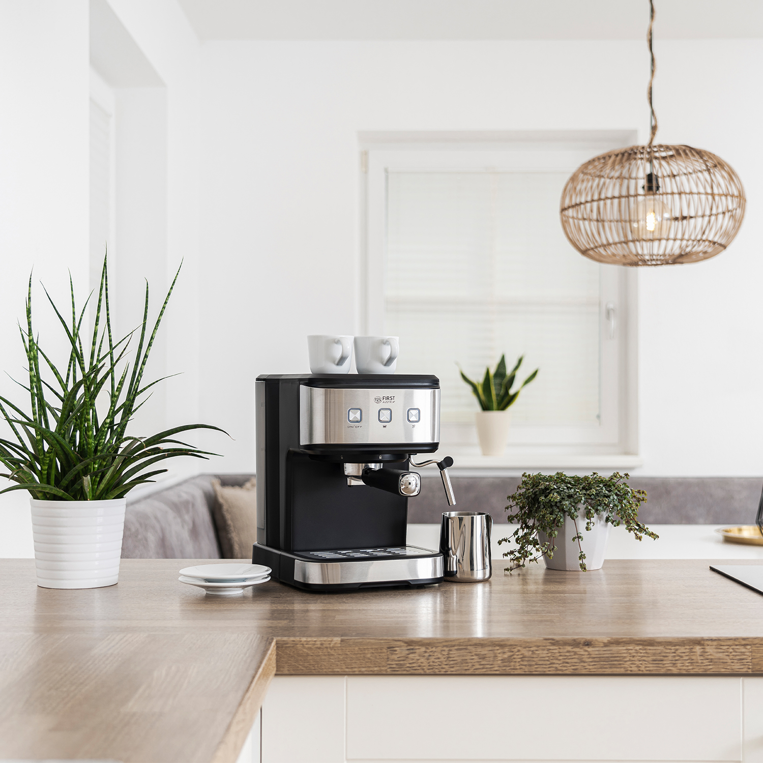Küche mit Espressomaschine, Tassen und Pflanzen auf einer Holz-Arbeitsplatte.