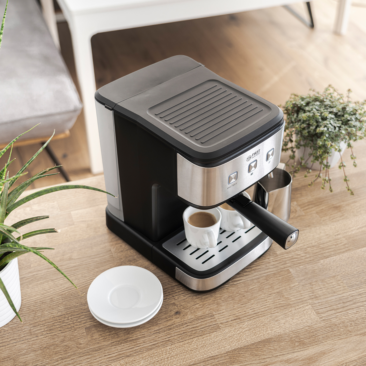 Espressomaschine auf Holzoberfläche mit einer Tasse Kaffee und Untertasse, plus Pflanze im Hintergrund.