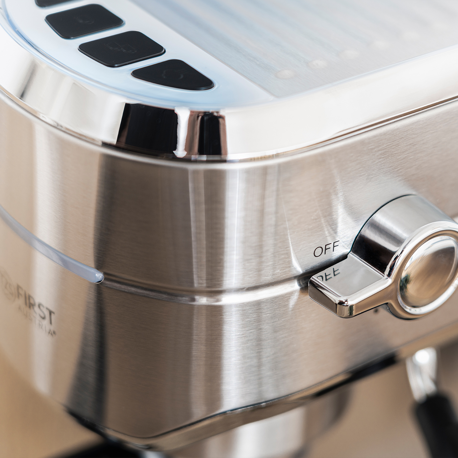 Nahaufnahme einer silbernen Espressomaschine mit Chromdetails. Ein Schalter lautet 'OFF'.