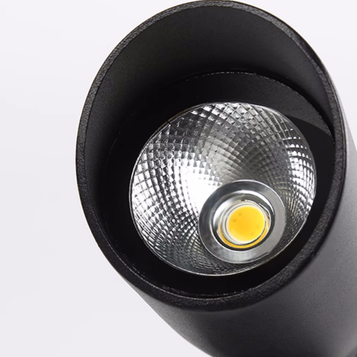 Nahaufnahme einer schwarzen zylindrischen LED-Leuchte mit heller zentraler Glühbirne.