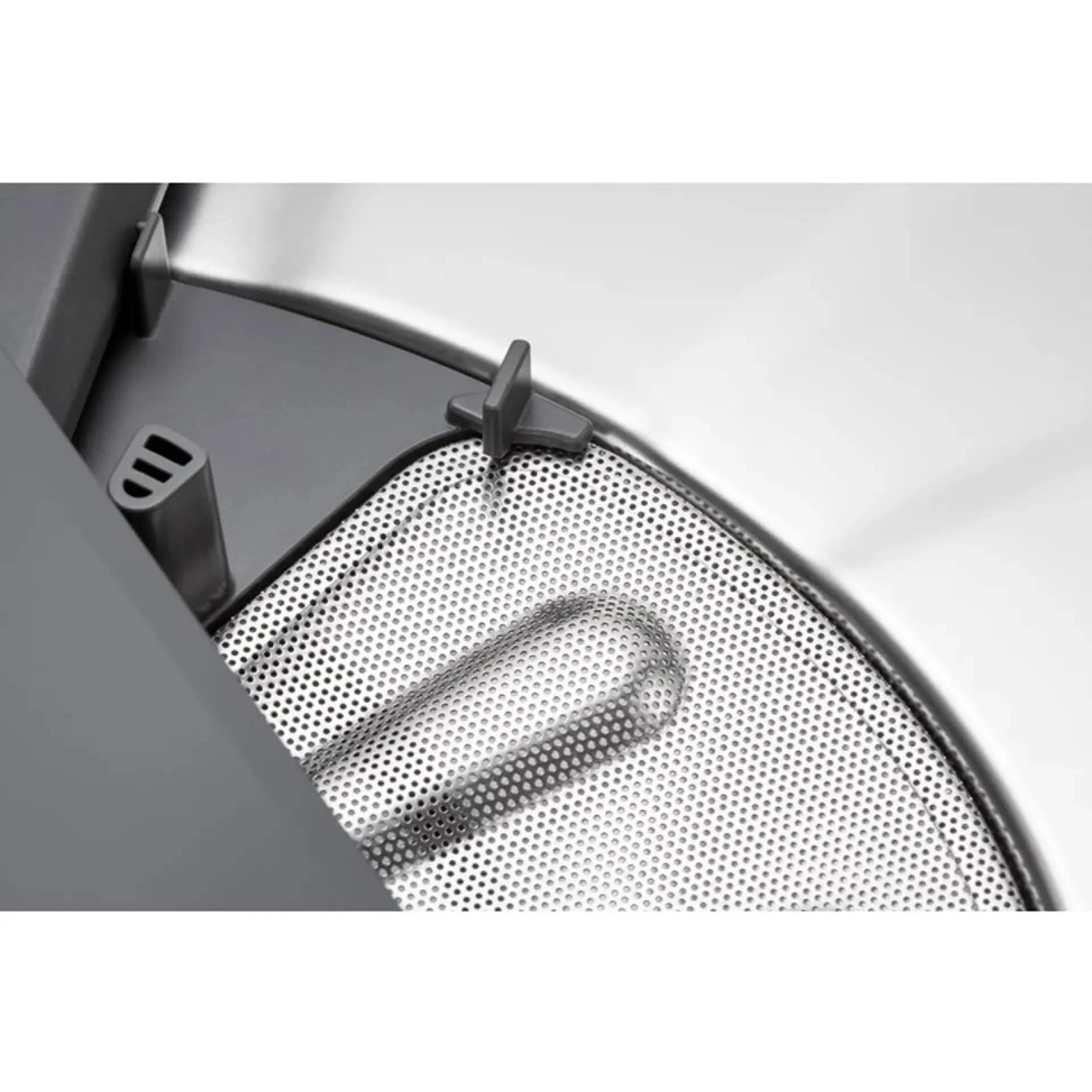 Zbliżenie metalowego filtra i szarej ramy wewnątrz urządzenia.