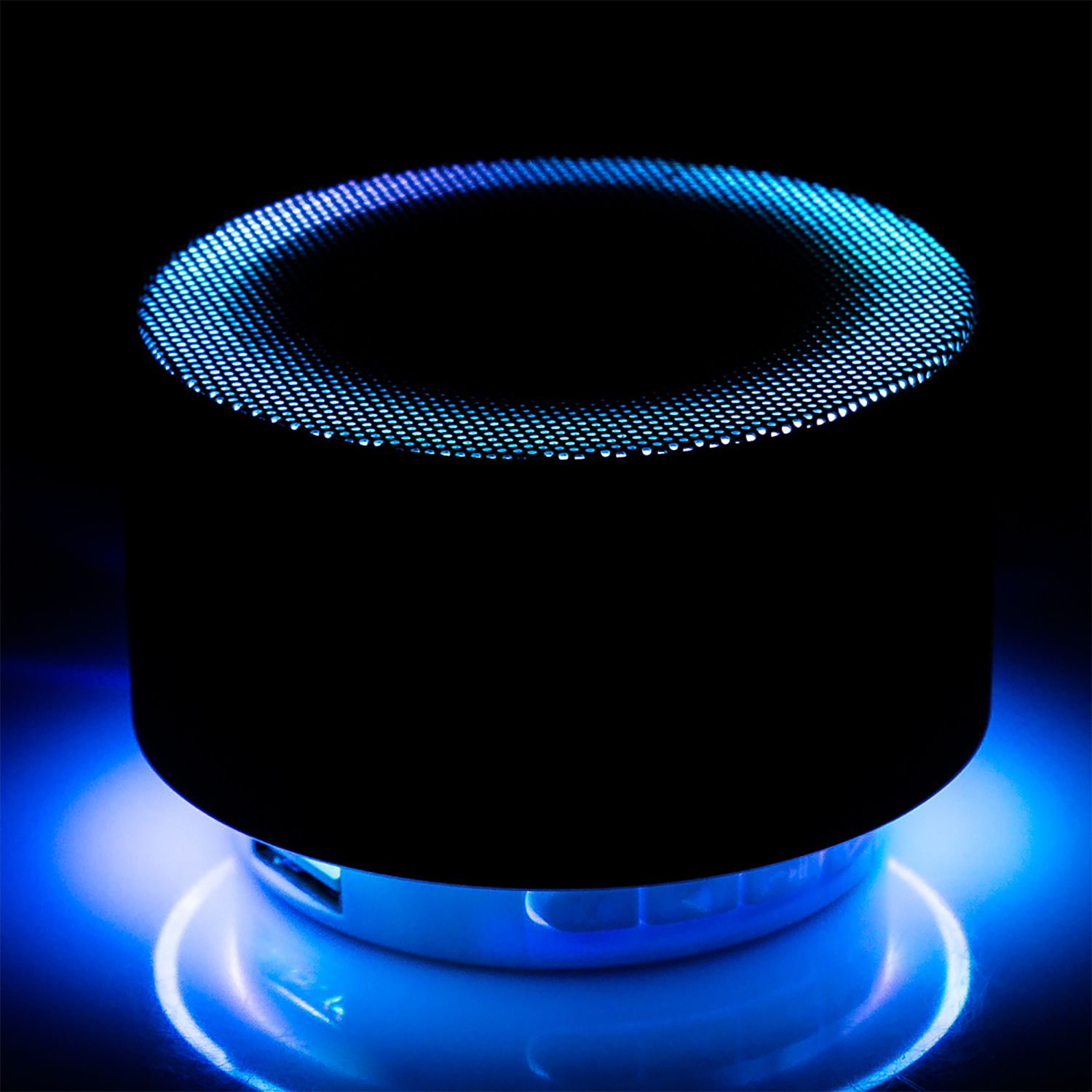 Primo piano di un altoparlante cilindrico nero con illuminazione blu sopra e sotto.