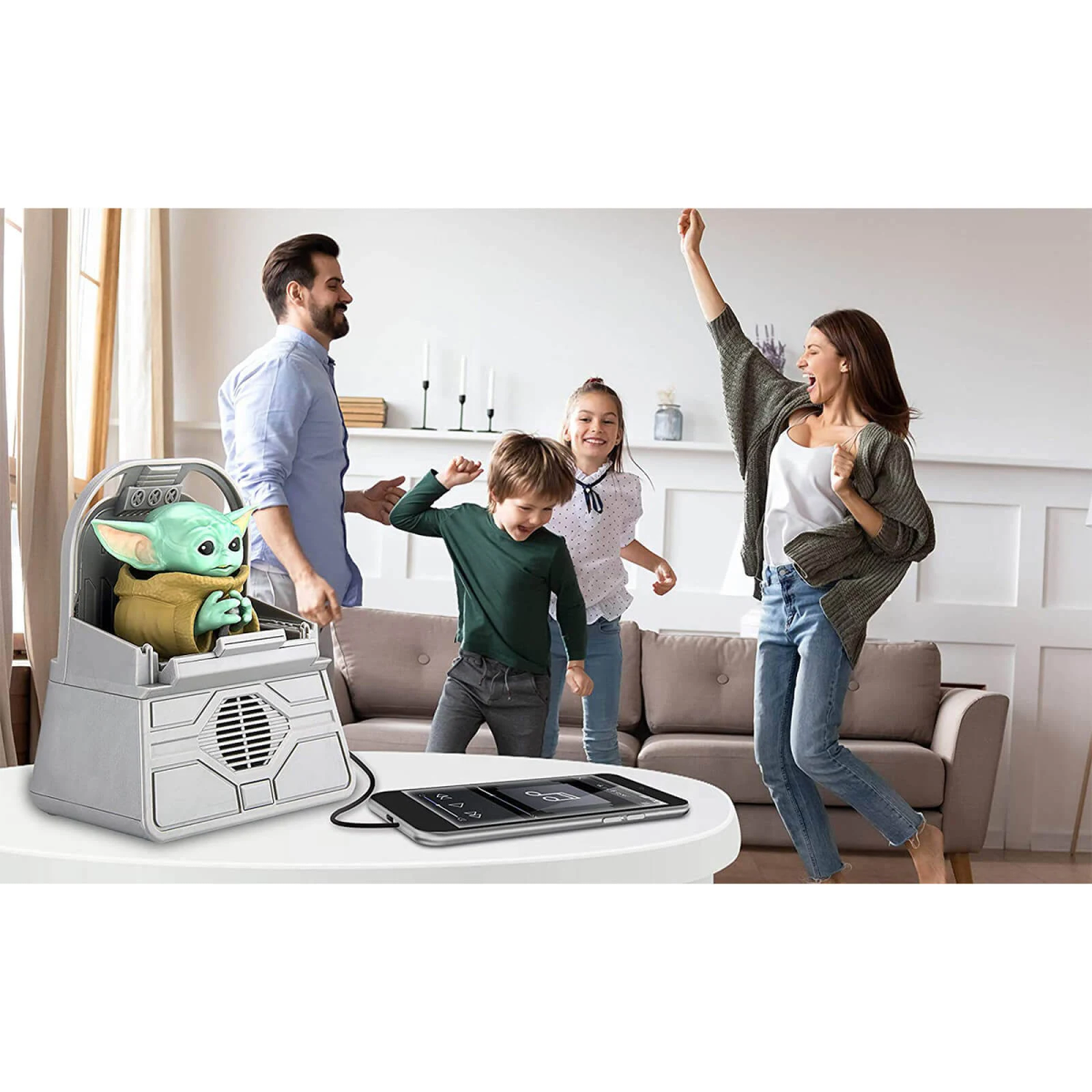 Familia jugando con un altavoz Grogu y bailando en una habitación blanca.