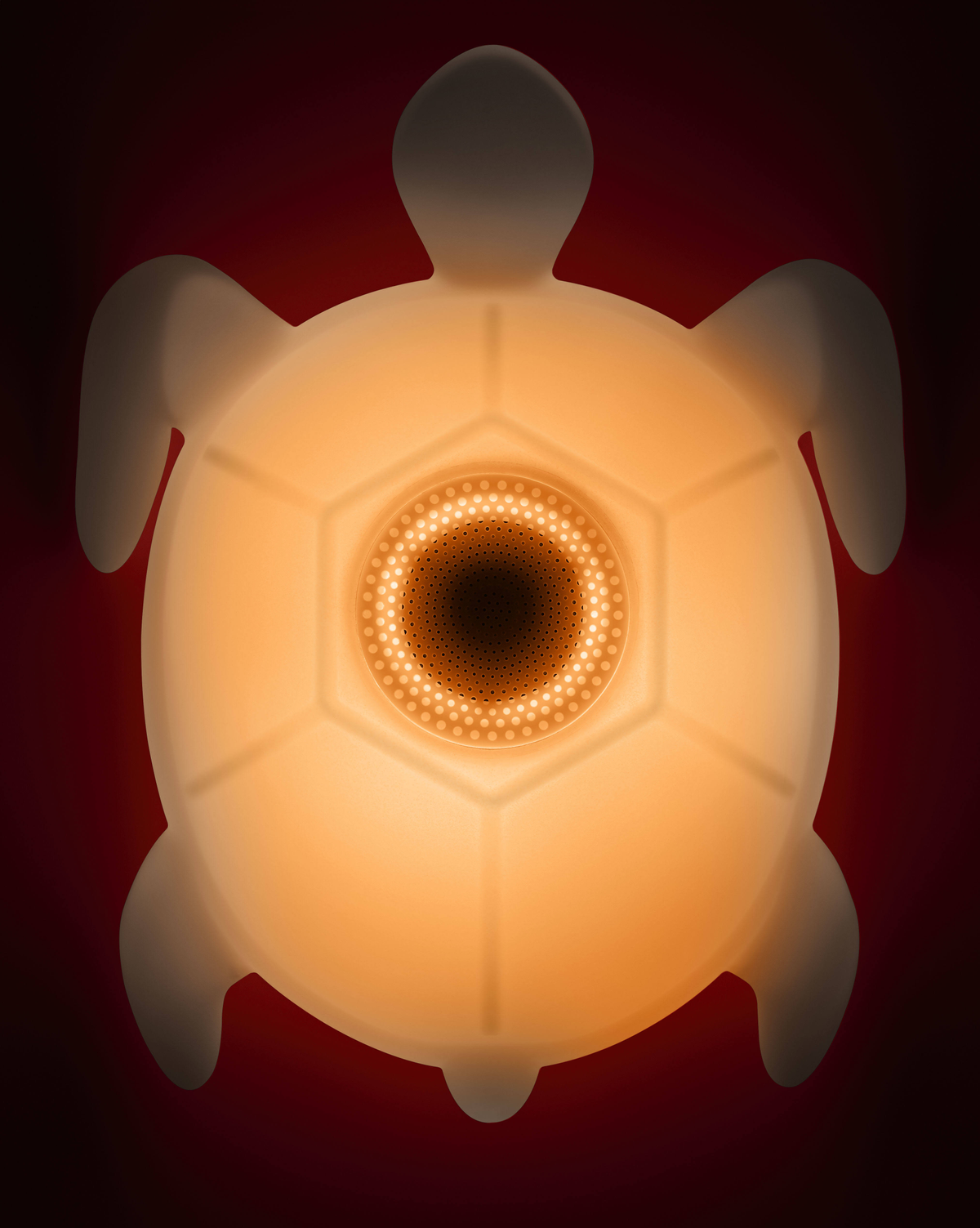 Lampka nocna w kształcie żółwia. Żółte światło z centralnym okręgiem światła. Czerwone tło.