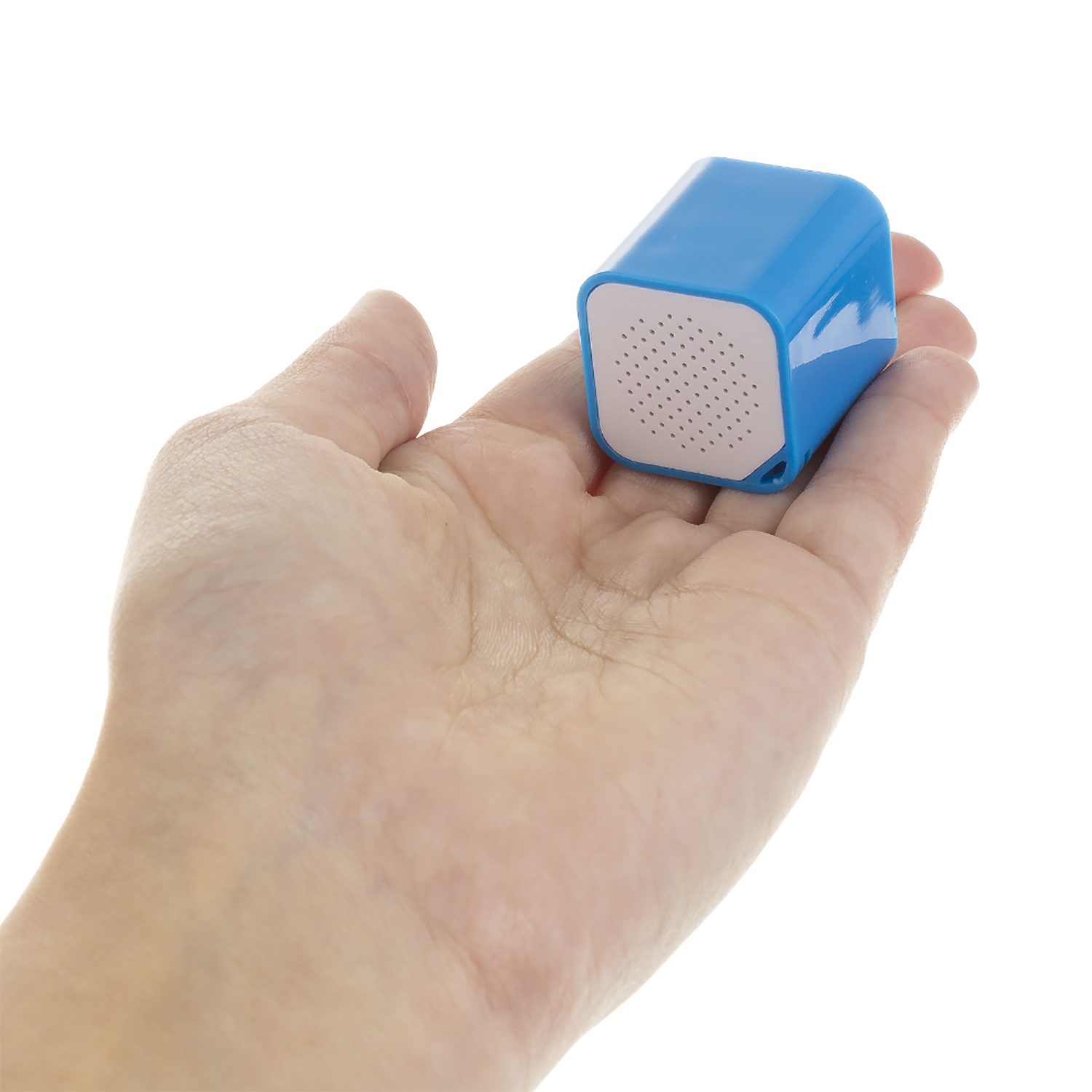 Ein kleiner, blauer, würfelförmiger Bluetooth-Lautsprecher wird von einer Person gehalten.