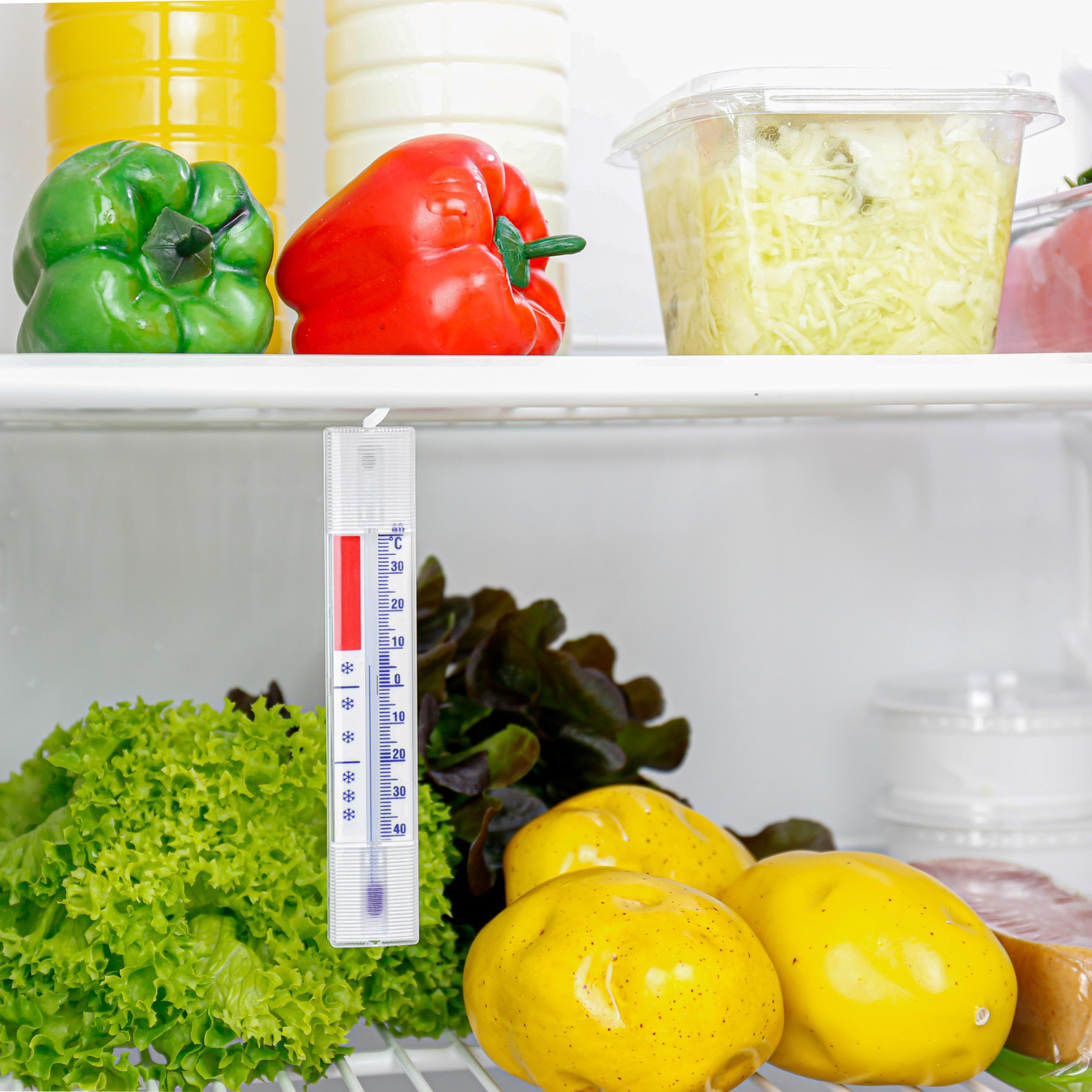 In einem Kühlschrank mit Gemüse, Obst und einem Thermometer.