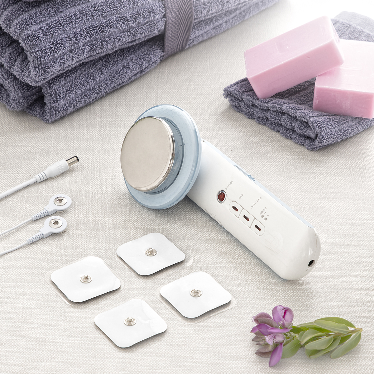 Dispositivo di bellezza bianco, cuscinetti, sapone e asciugamano.