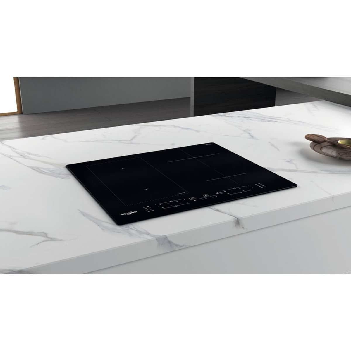 Een zwarte Whirlpool inductiekookplaat op een wit aanrecht. Voorzien van bedieningselementen en inductieringen.