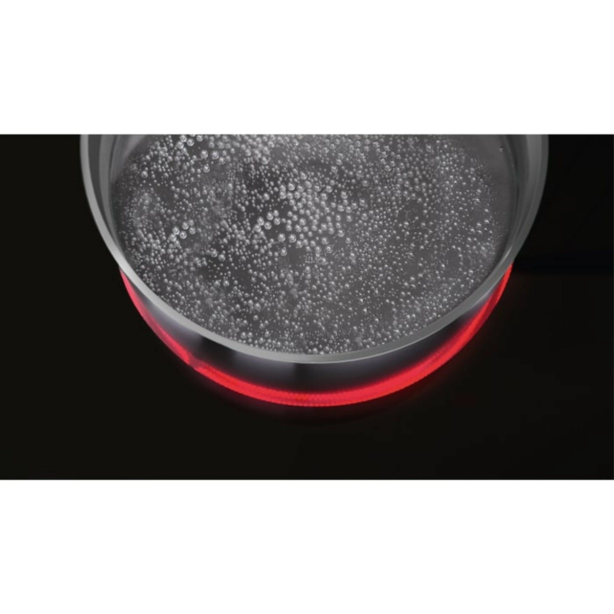 Zbliżenie garnka z wrzącą wodą na czerwono podświetlanej płycie grzewczej.