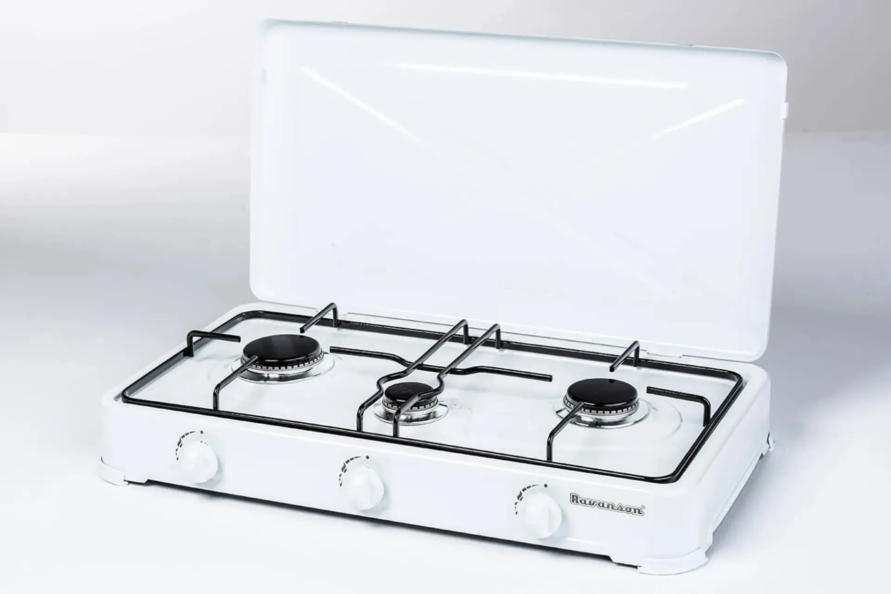 Biała przenośna kuchenka gazowa z trzema palnikami, otwartą pokrywą i pokrętłami.